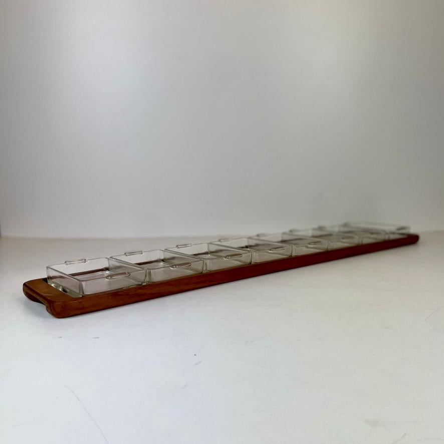 Raro vassoio danese per aperitivi di grandi dimensioni con 9 ciotole in vetro di Esa, anni '60,.
È un articolo fantastico da possedere quando si hanno amici a cena o per una festa.
La base in legno è in legno di teak.
 
