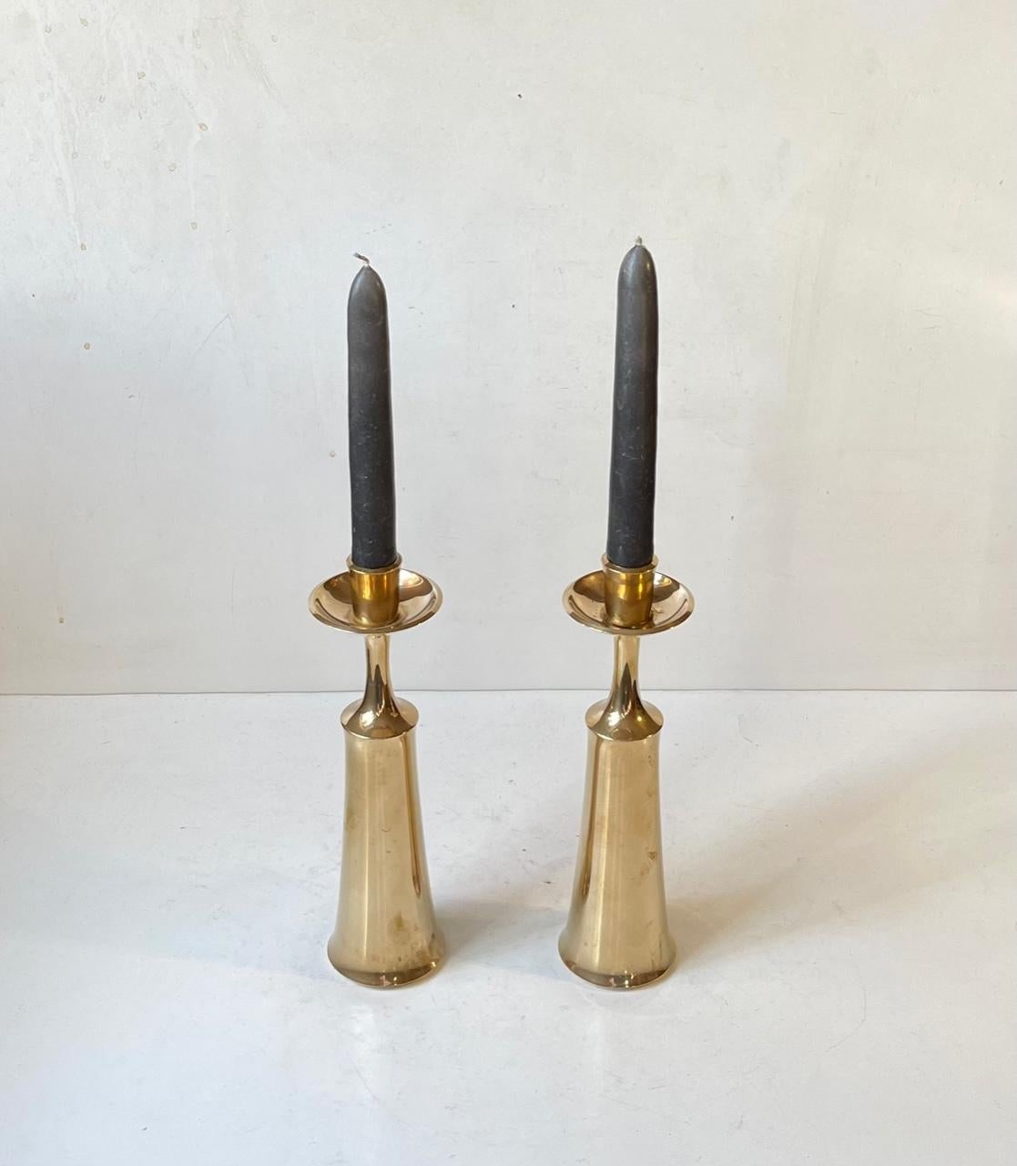 A pair of large candlesticks in engine turned solid brass. Designed in the late 1950s by Danish Industrial design icon Jens Harald Quistgaard (IHQ). They are to be used with regular sized candles. Both fully imprinted and signed beneath their base.