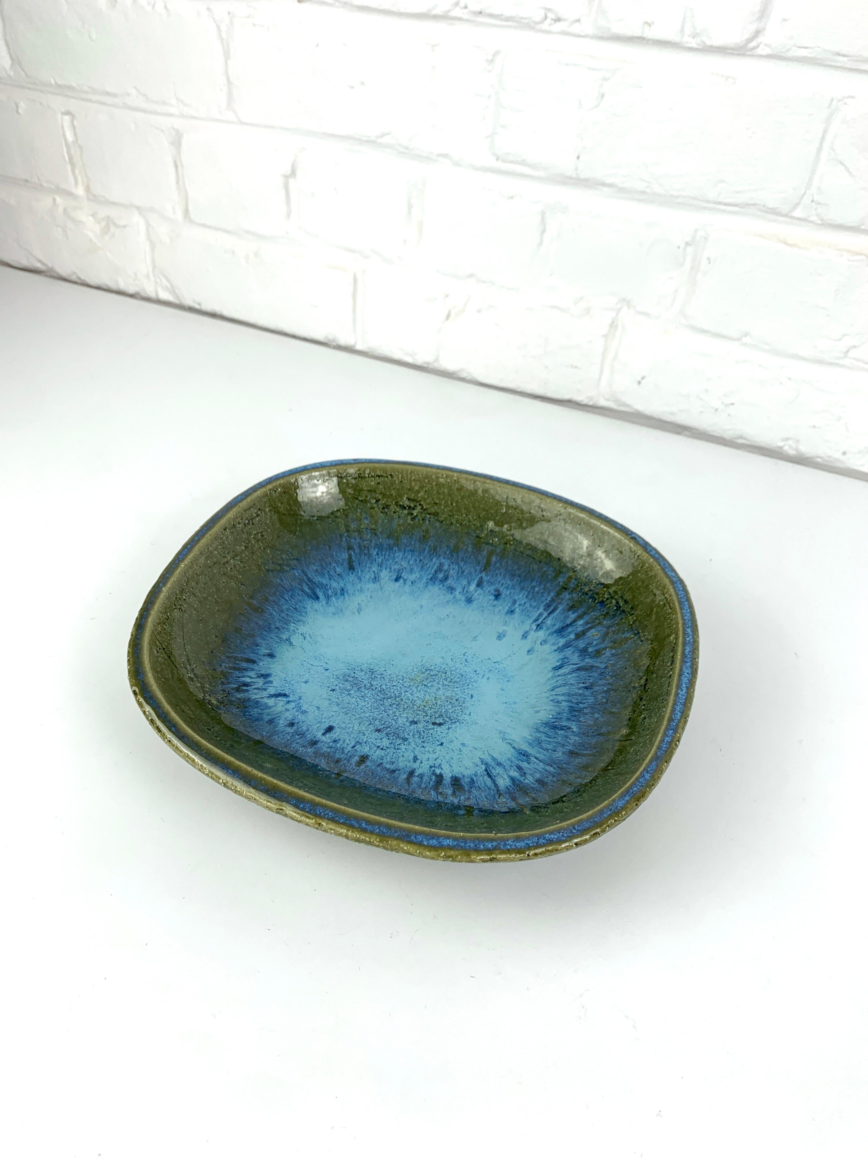 Large ceramic vide-poche or low bowl in olive green tones with an impressive blue flame in the center.  The blue effects are replicated onto the outside edge. It comes with a thick glaze.

Scandinavian Mid-Century 1960s, produced by Palshus