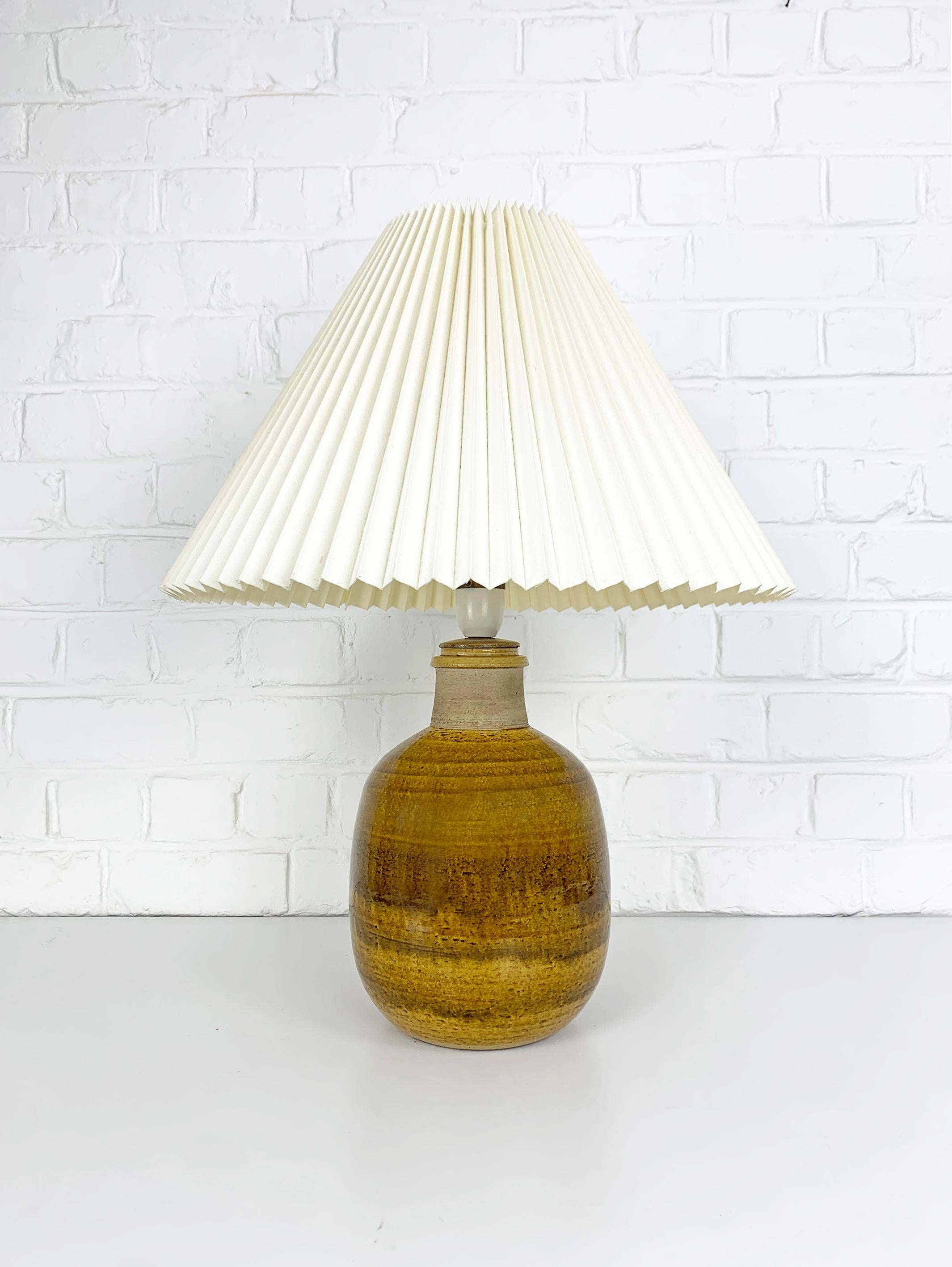 Stoneware table lamp in uranium yellow / beige / ocre glaze and natural stoneware finish. Designed by Nils Kähler in the 1960s or 1970s. 

Manufactured in the workshop of Herman A. Kähler Ceramic (HAK) in the town of Naestved in southern