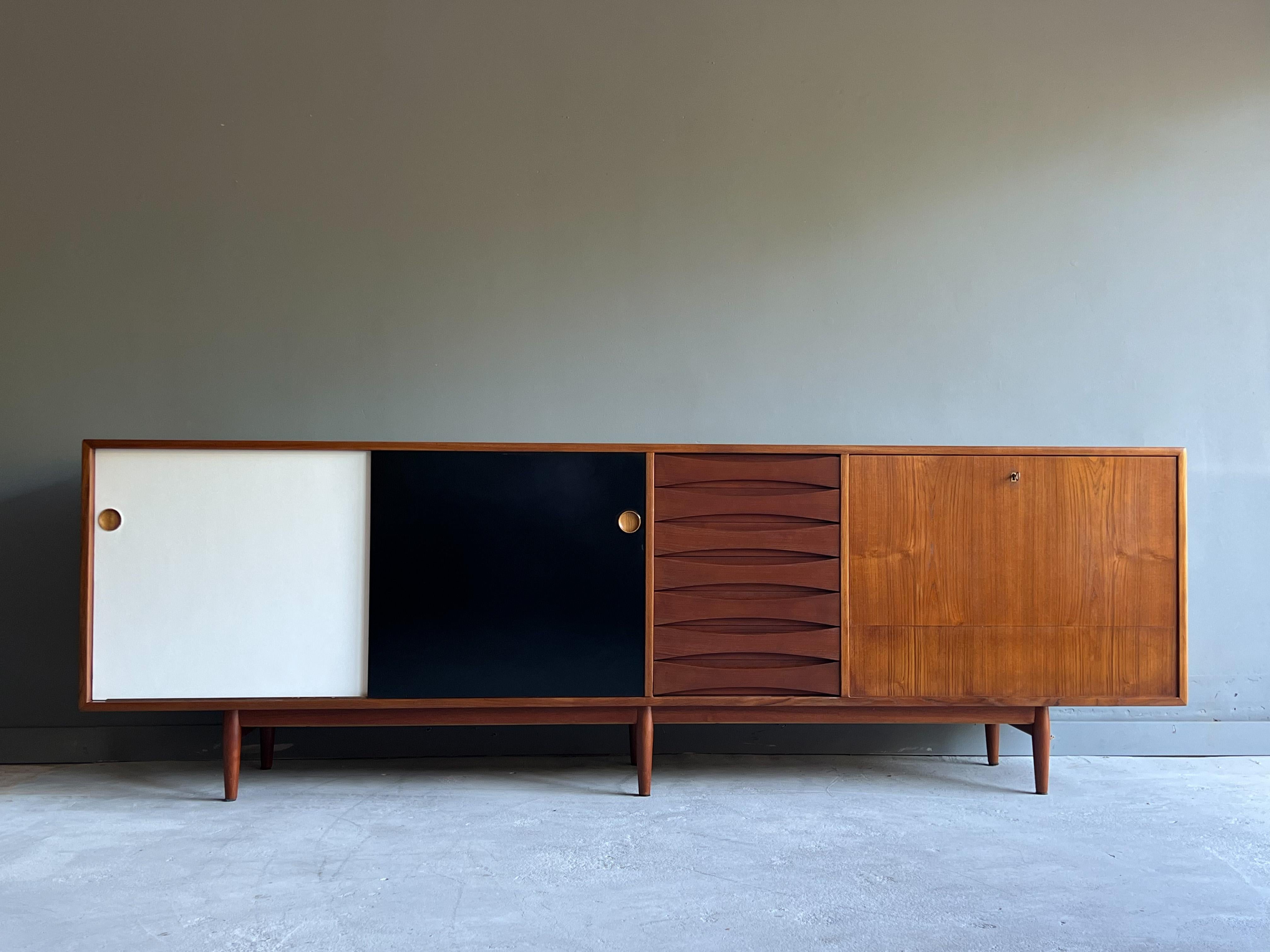 Large and uncommon Danish credenza by Arne Vodder for Sibast. This beautiful example, model 29-A, has it all. From Vodder’s signature eye lid drawer pulls, reversible lacquer doors, elegant legs and commanding scale, it’s no wonder why this design