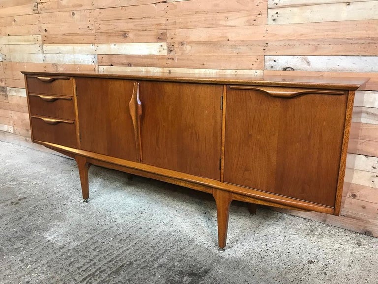Large Danish designed midcentury teak retro sideboard, 1960s, lovely top and sliding doors, three drawers and stands on nice solid teak legs. It has beautiful detailing from the simply stunning matching grain to the handcrafted