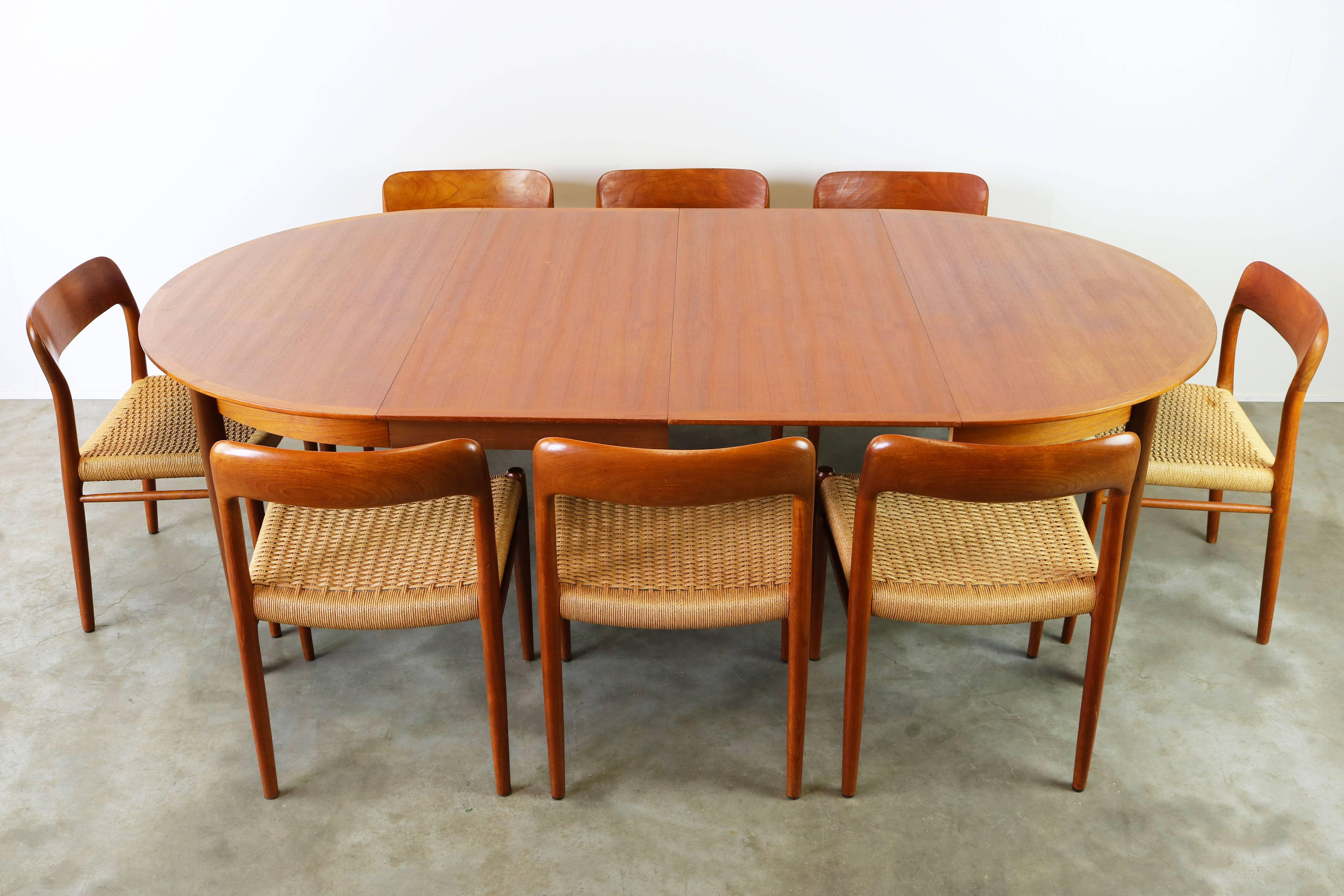 Very large and rare dining room set designed by Niels Otto Møller and produced by J.L Mollers in the 1950s. The set has eight Model 75 chairs in teak and papercord. and a large round (twice extendable) table in teak. 
The table can be used round
