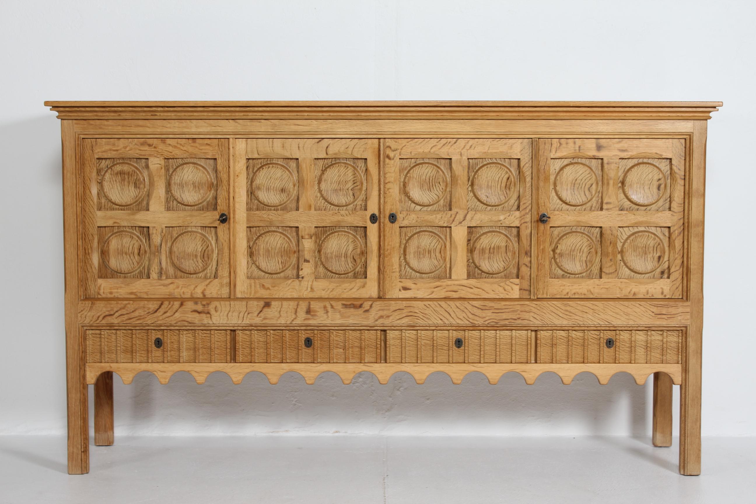Sideboard by designer Henning Kjærnulf.
Most likely manufactured by the Danish company Nyrup Møbelfabrik/ EG Furniture, Denmark in the 1970s.

The country and brutalist style sideboard is made of solid and veneered  oak with four raised panel doors