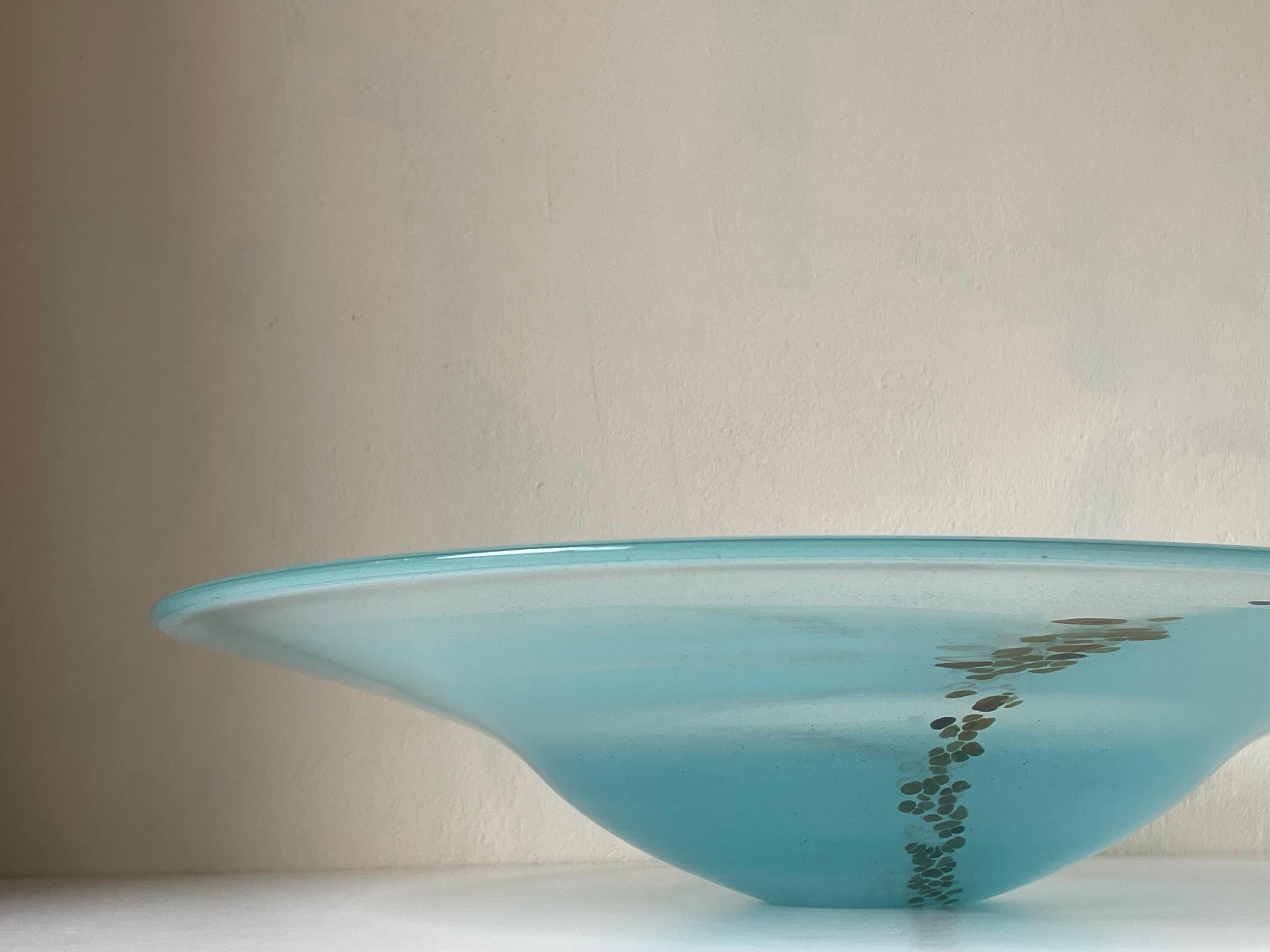 Wide translucent light blue mouth blown art glass centerpiece bowl for decoration or serveware. Organic blue, white and caramel colored bubble decor from one side to the other resembling an underwater scenery or pebbles on a beach. Beautiful vintage