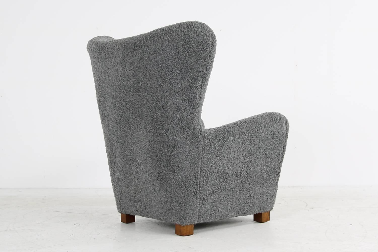 Beautiful Teddy bear fur covered wingchair from Denmark, early 1950s attributed to Thorald Madsen or Flemming Lassen, very unique shape, large size, heavy weight. Solid stained beechwood legs. Great upholstery and buttons in the backrest. Design
