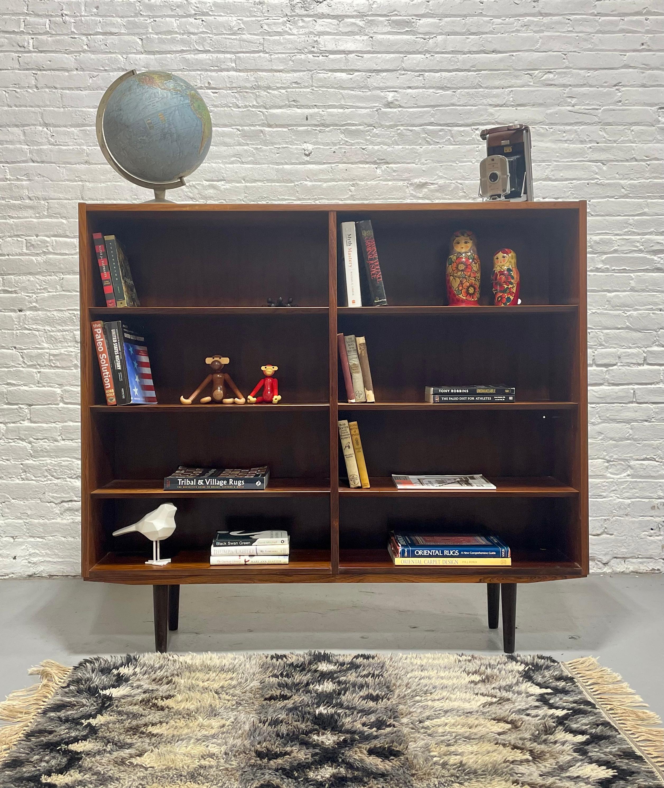 Exquisite Mid Century Modern ROSEWOOD bookcase featuring 8 wide and spacious shelving areas, stunning wood grains throughout and adjustable + removable shelves. The design is classic and elegant with the clean lines and simple design that define mid