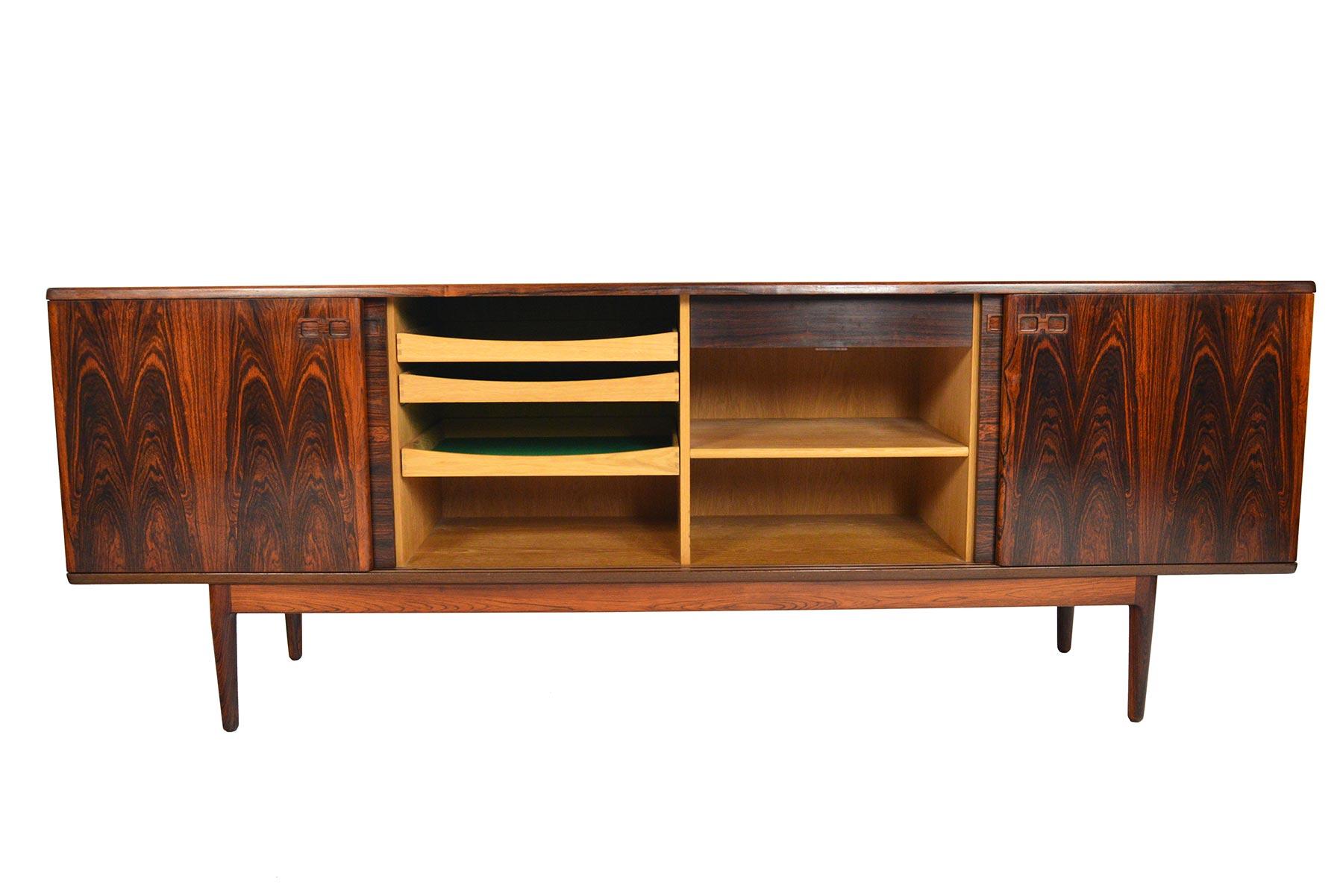 This large sliding door credenza offers a simple design highlighted by hand- selected cuts of Brazilian rosewood. Each pair of doors offers a different orientation of book- matched wood grain and showcases cathedral patterns. Doors are adorned with