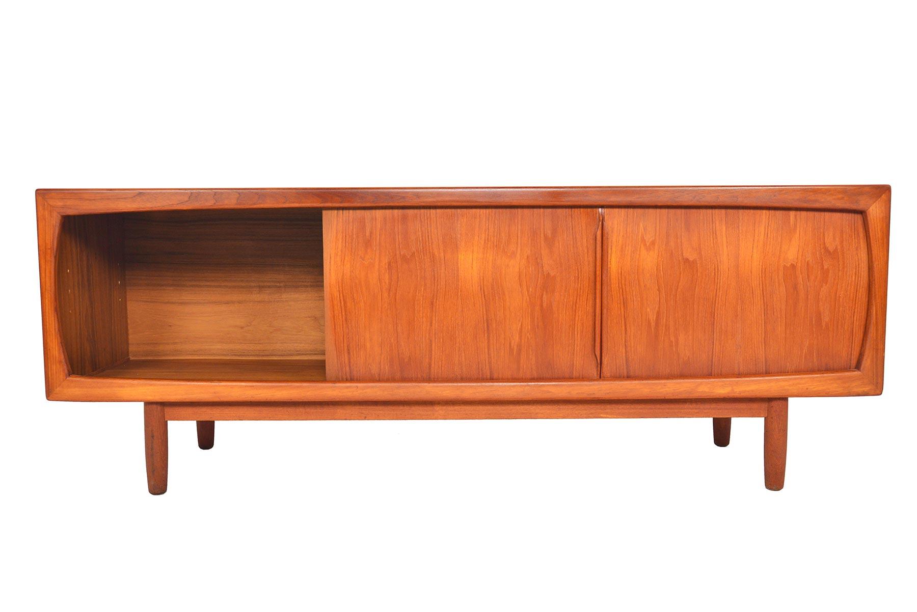 This beautiful Danish modern midcentury teak credenza offers a wonderfully functional configuration for modern living! Executed with clean lines and Minimalist details, left and right doors slide open to open bays. Four center drawers provide
