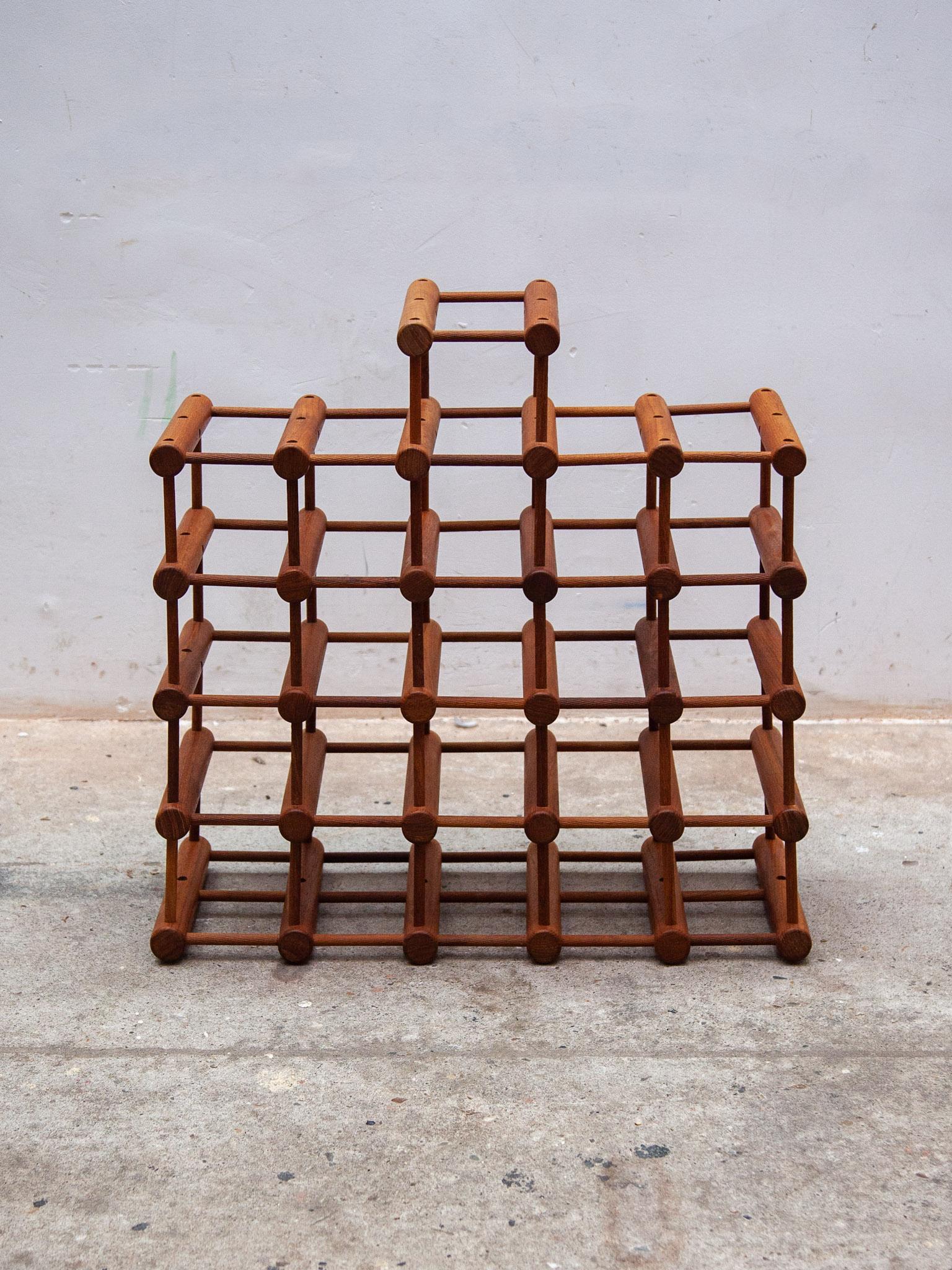 Original Danish teak modular wine rack designed by Richard Nissen and made in Denmark by Langaa. This rack to use for 26 wine bottles has an ingenious design consisting of solid teak pegs and dowels which can be taken apart and reconfigured in any