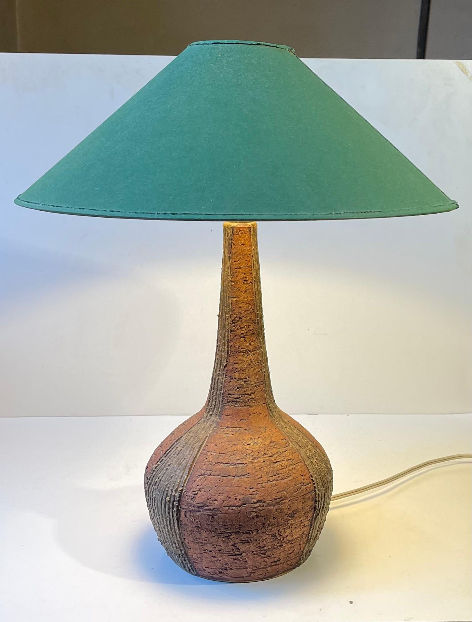 Large rustic table light in chamotte stoneware featuring a stylish grass green textile shade and pin on/of switch hidden just above the shade edge to the socket. It was designed by the Danish ceramist F. Sejersen and made at his studio Sejer in