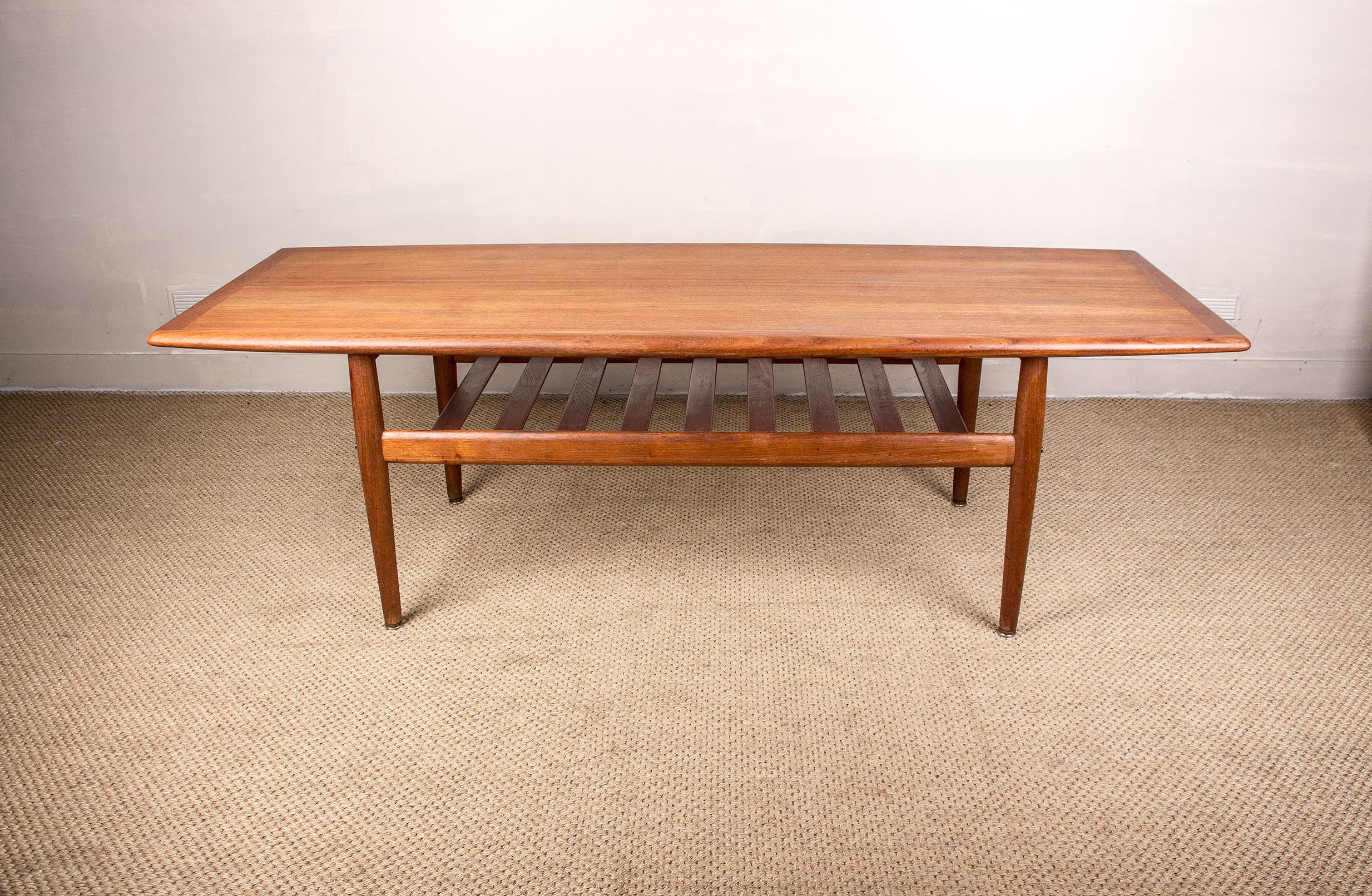 Magnifique et grande table basse scandinave, une section de porte-documents en dessous et un grand et très élégant plateau avec sa forme légèrement oblongue et ses incrustations en laiton discrètes. Meubles répertoriés sur le site web du Design