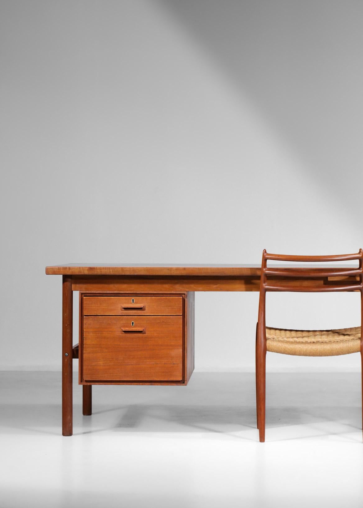 Scandinavian desk from the 1960s. Structure in solid teak and teak veneer, consisting of a hanging pedestal with two drawers on one side and a shelf with a hinged door on the other side and a retractable shelf. The set has a traditional Scandinavian