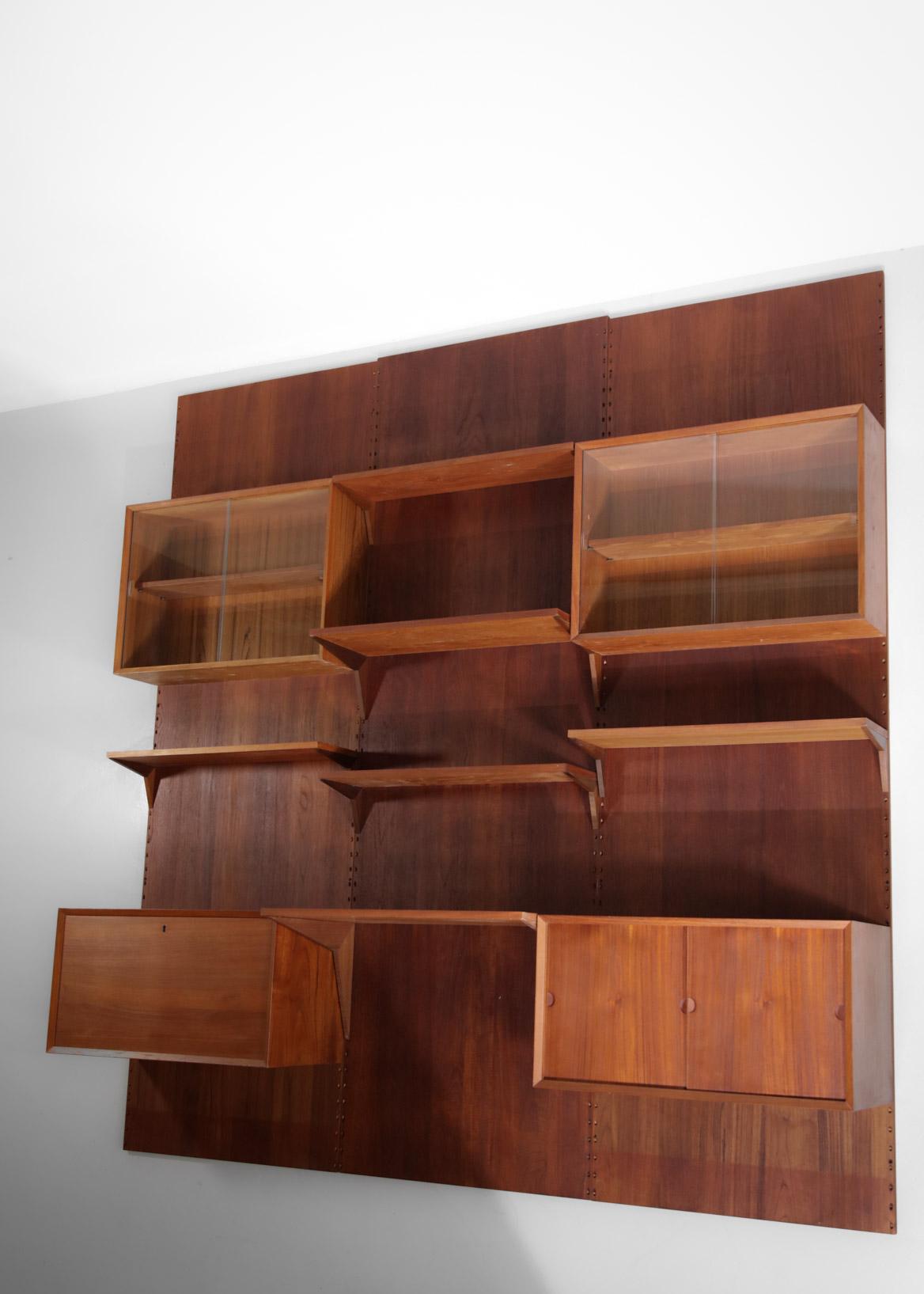 Imposing wall bookcase from the 60's designed by the Danish designer Poul Cadovius. This bookcase is composed of different modular elements on four sides, the configuration of each box or shelf can be changed according to your needs. Solid teak