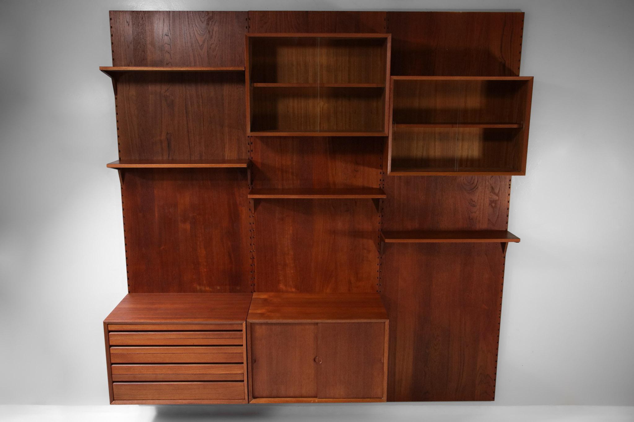 Large wall bookcase from the 60's designed by the Danish designer Poul Cadovius. This bookcase is composed of different modular elements on three modules, the configuration of each box or shelf can be changed according to your needs. Structure in