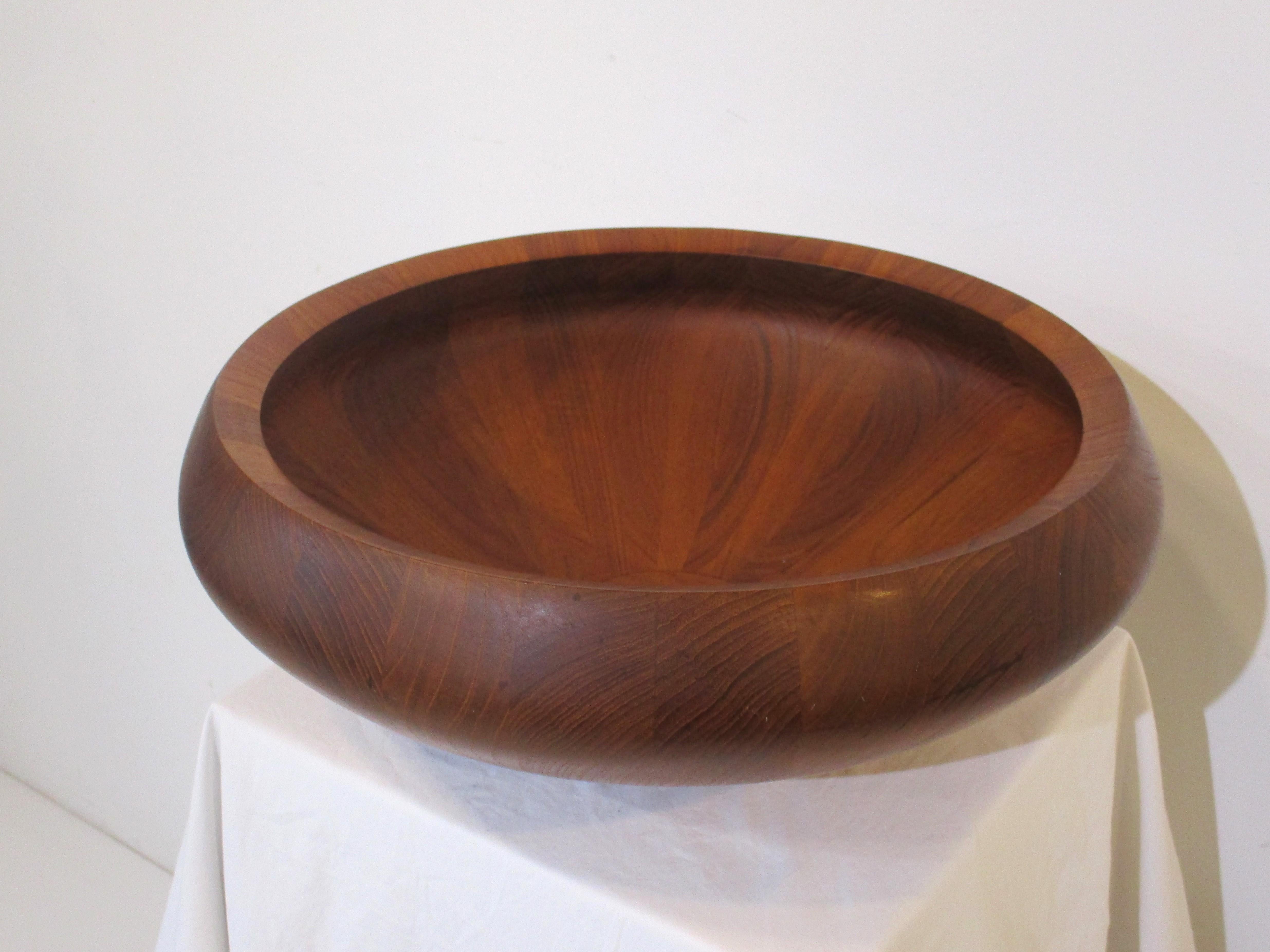 A large Mid Century staved teak center piece or serving bowl with rounded edges and beveled top rim . Early production with the three duck mark and branded Dansk manufactures mark , a great piece for the table or kitchen made in Denmark . 