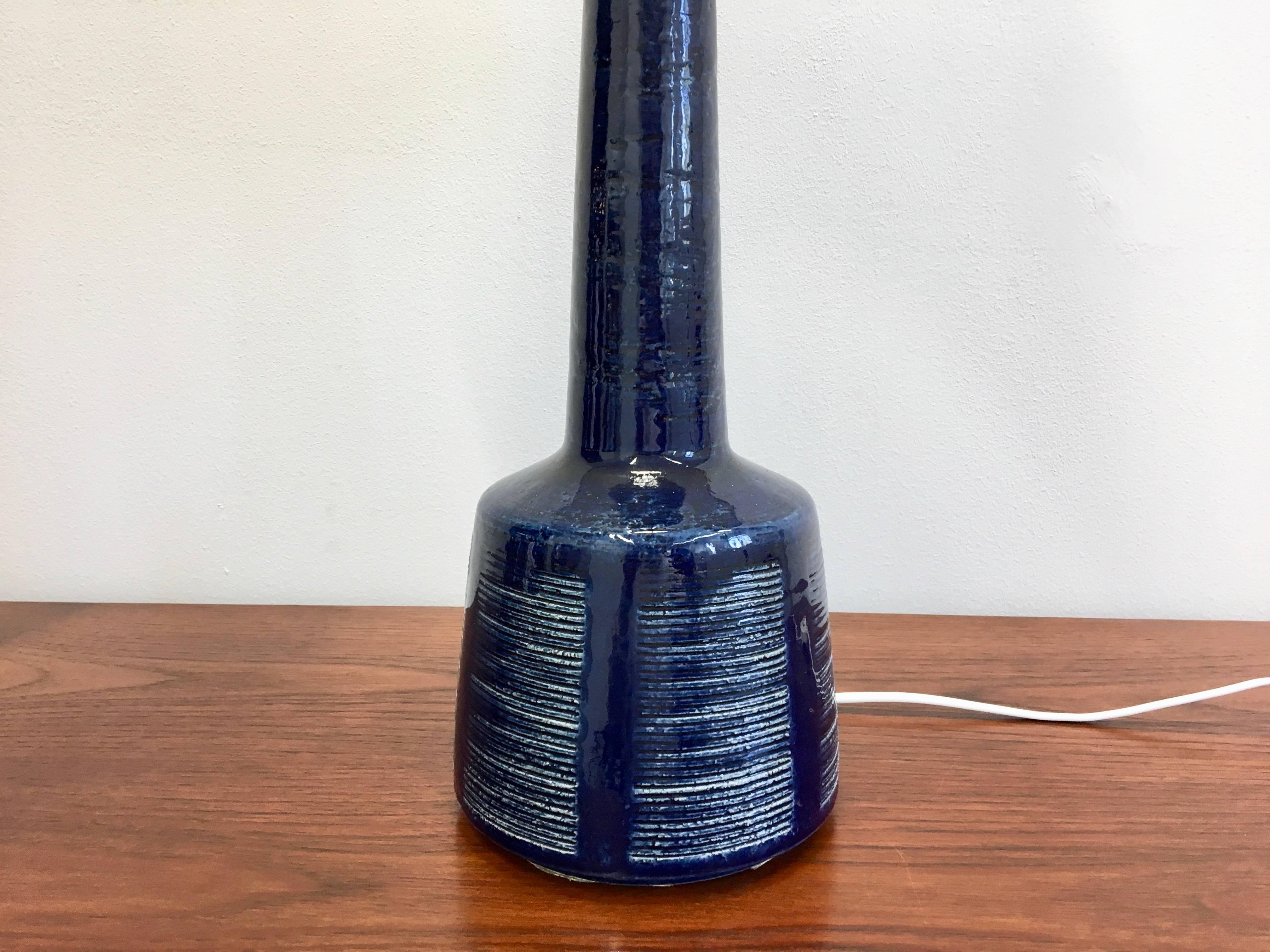 This ceramic table lamp was designed by Esben Klint and produced by Palshus in Denmark in the 1960s. The lamp is made of chamotte clay and has a dark blue glaze over a geometric pattern.
Rewired for European standard and new lampshade.