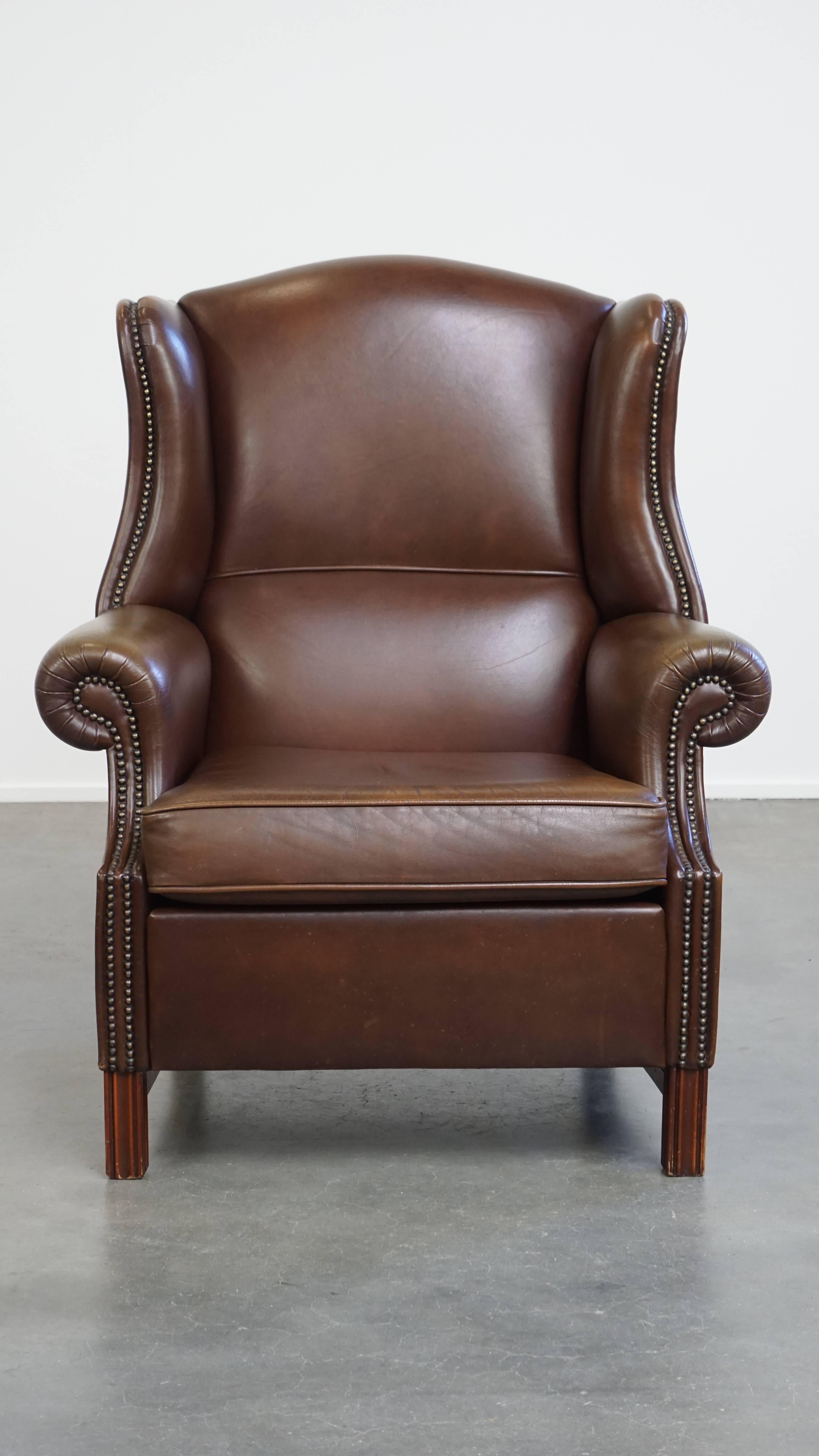 Offered here this large, classic dark brown cowhide leather Chesterfield wingback chair in English style.

This beautiful, generously sized wingback armchair is crafted from high-quality cowhide leather and fits seamlessly into both classic and