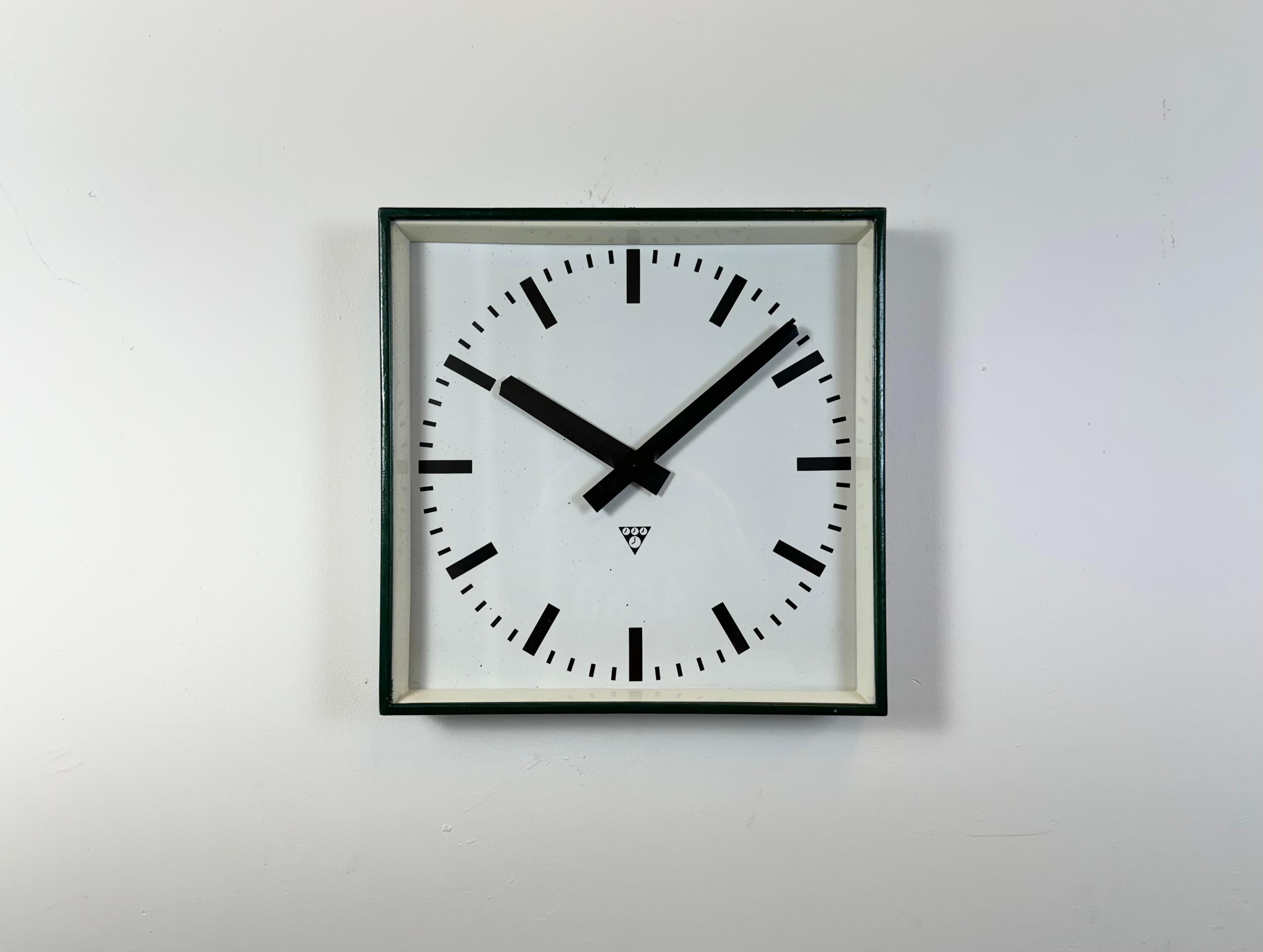 - Reloj de pared diseñado por Pragotron en la antigua Checoslovaquia durante la década de 1970 y fabricado hasta la década de 1990
- Se utilizaba en fábricas, escuelas y estaciones de ferrocarril 
- Estructura de metal verde oscuro 
- Esfera y