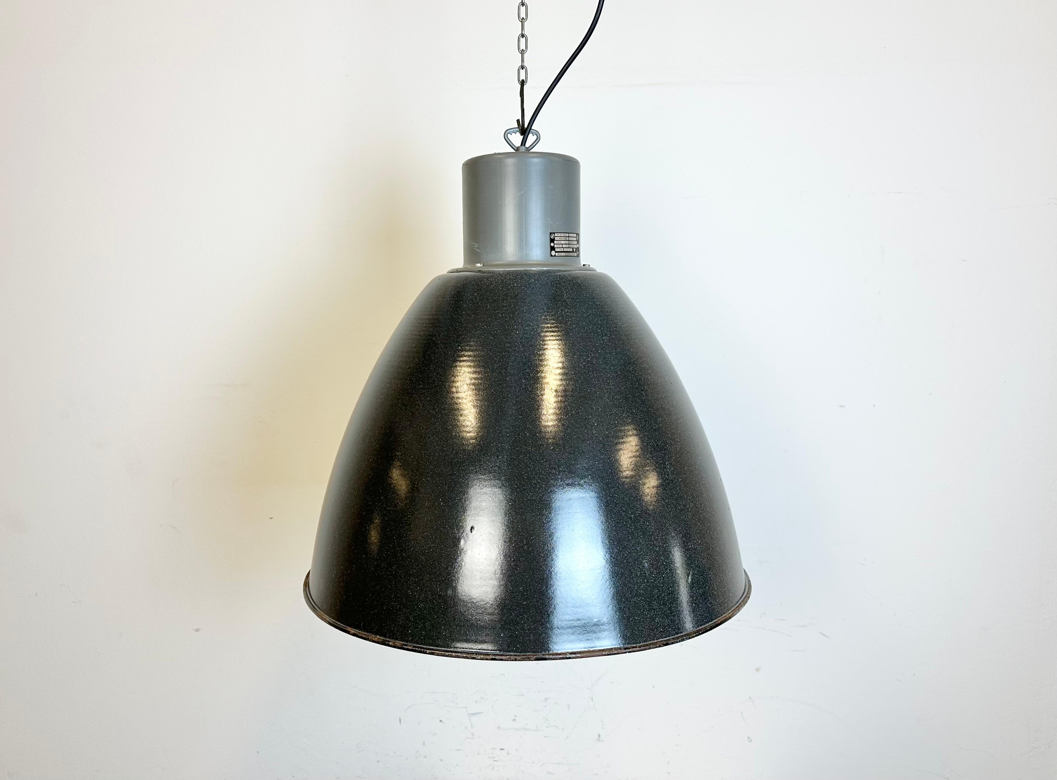 This grey Industrial pendant light was designed in the 1960s and produced by Elektrosvit in former Czechoslovakia. It features a dark grey enamel shade with white enamel interior and an iron top with hook. New porcelain socket for E 27 / E 26