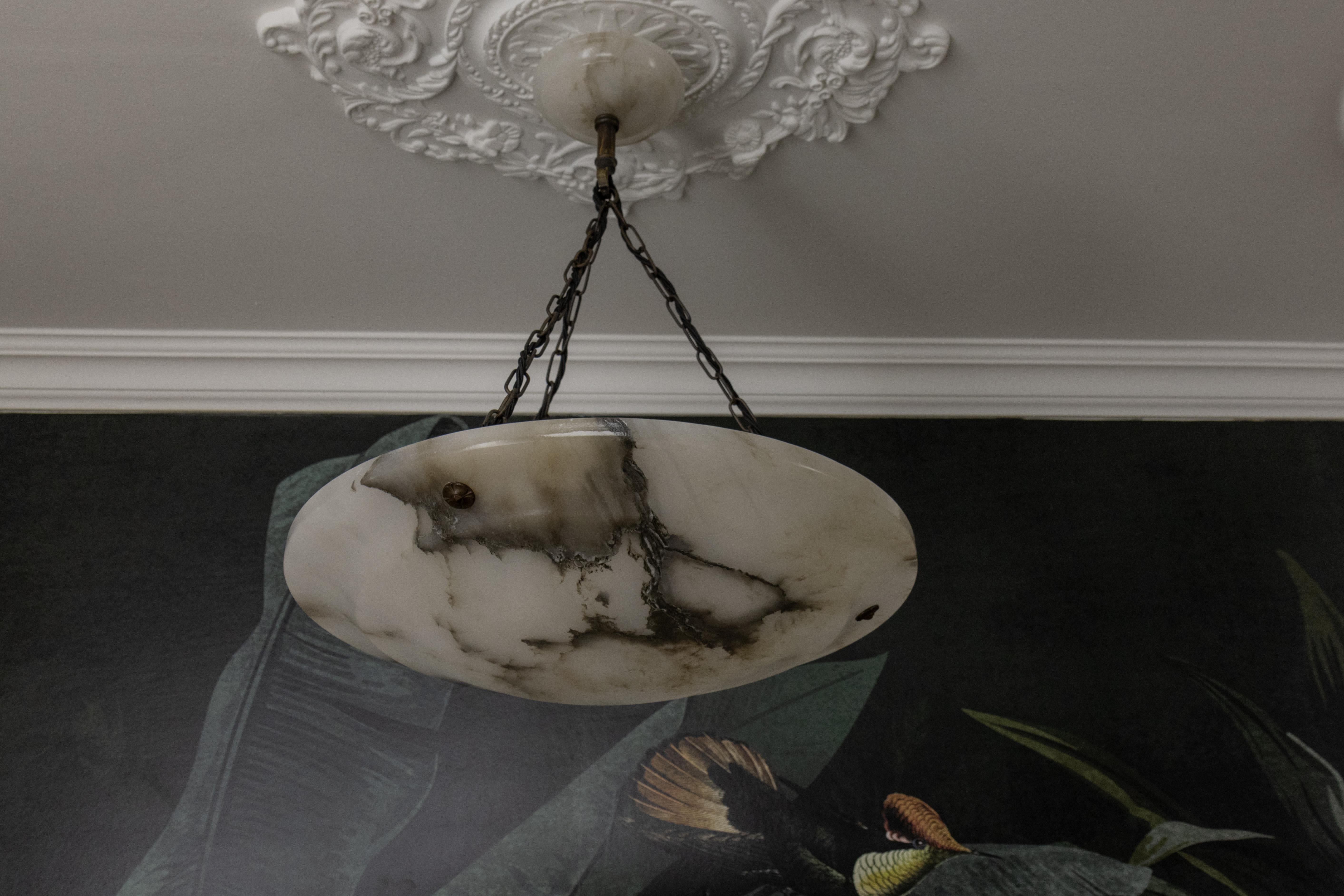 Large black and dark brown veined white alabaster pendant light fixture, France, circa the 1920s.
An impressive alabaster pendant light from circa the 1920s. The beautifully veined white alabaster bowl is suspended by chains and a matching alabaster