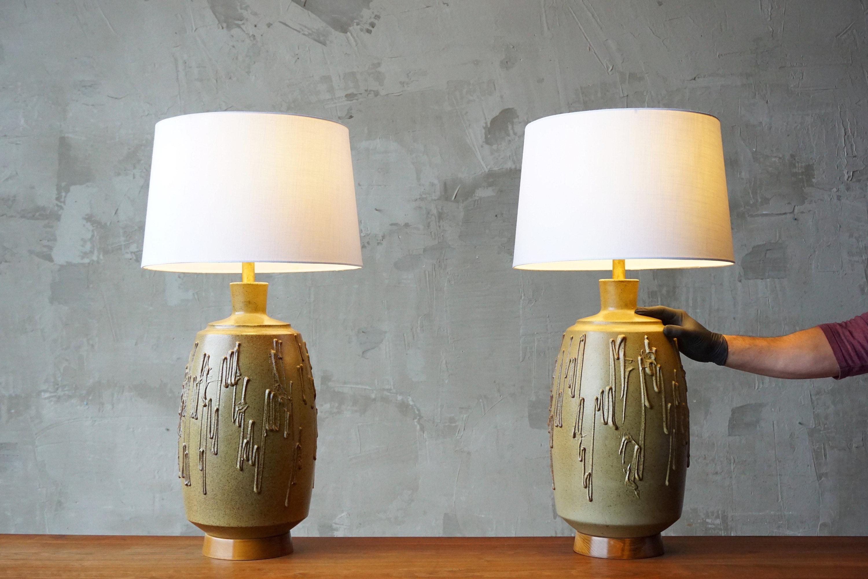 Pair of textured and glazed ceramic lamp designed by David Cressey for California company, Architectural Pottery. 

Both in excellent original condition. 

Each measures approximately 26”H to bulb socket base. Ceramic portion measures 20”H x