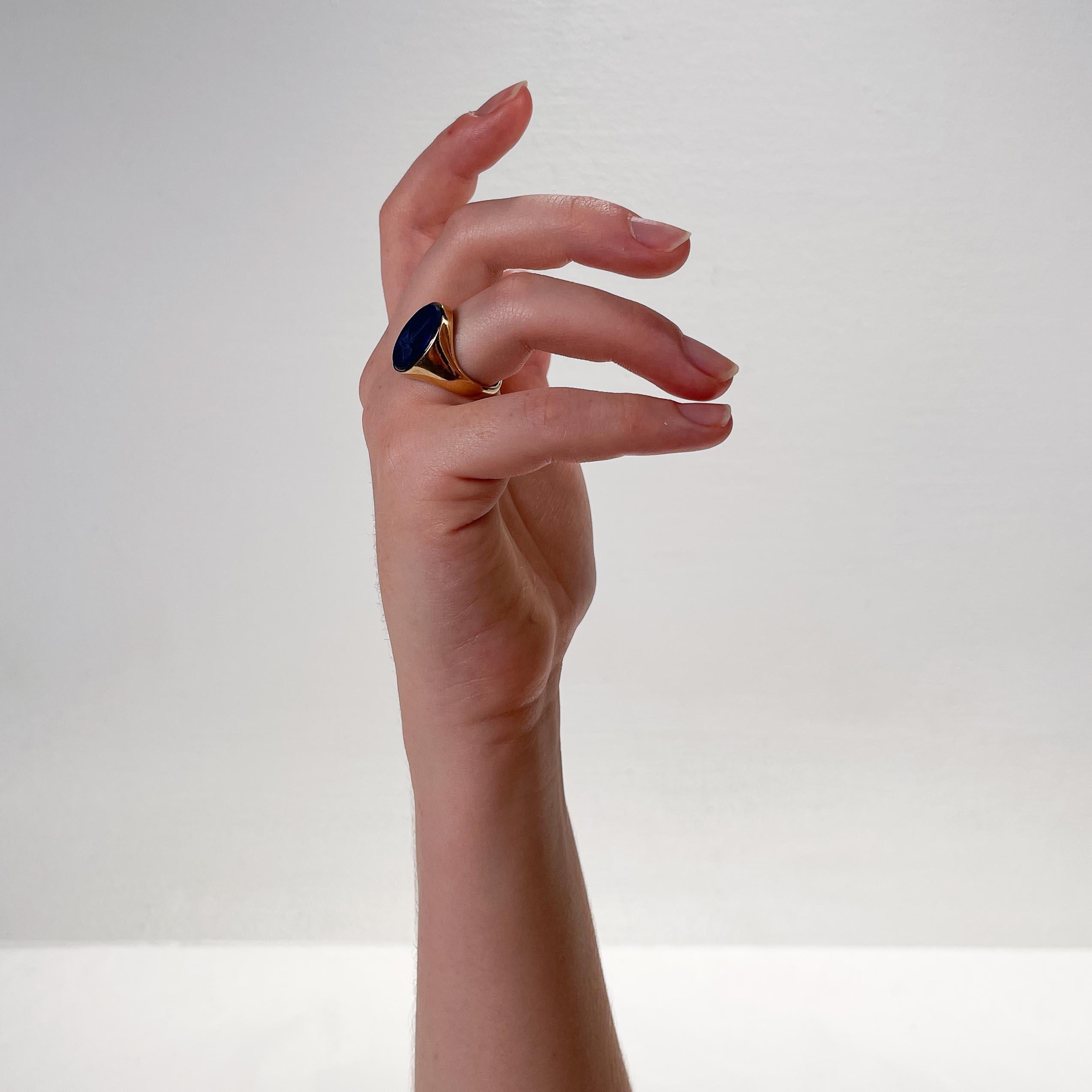 A fine, large English gold & lapis lazuli signet fing.

By the important Deakin & Francis jewelry firm.

In 9ct gold. 

With a bezel set carved intaglio oval lapis cabochon of (what appears to be) a crown and sword.

Deakin & Francis are long