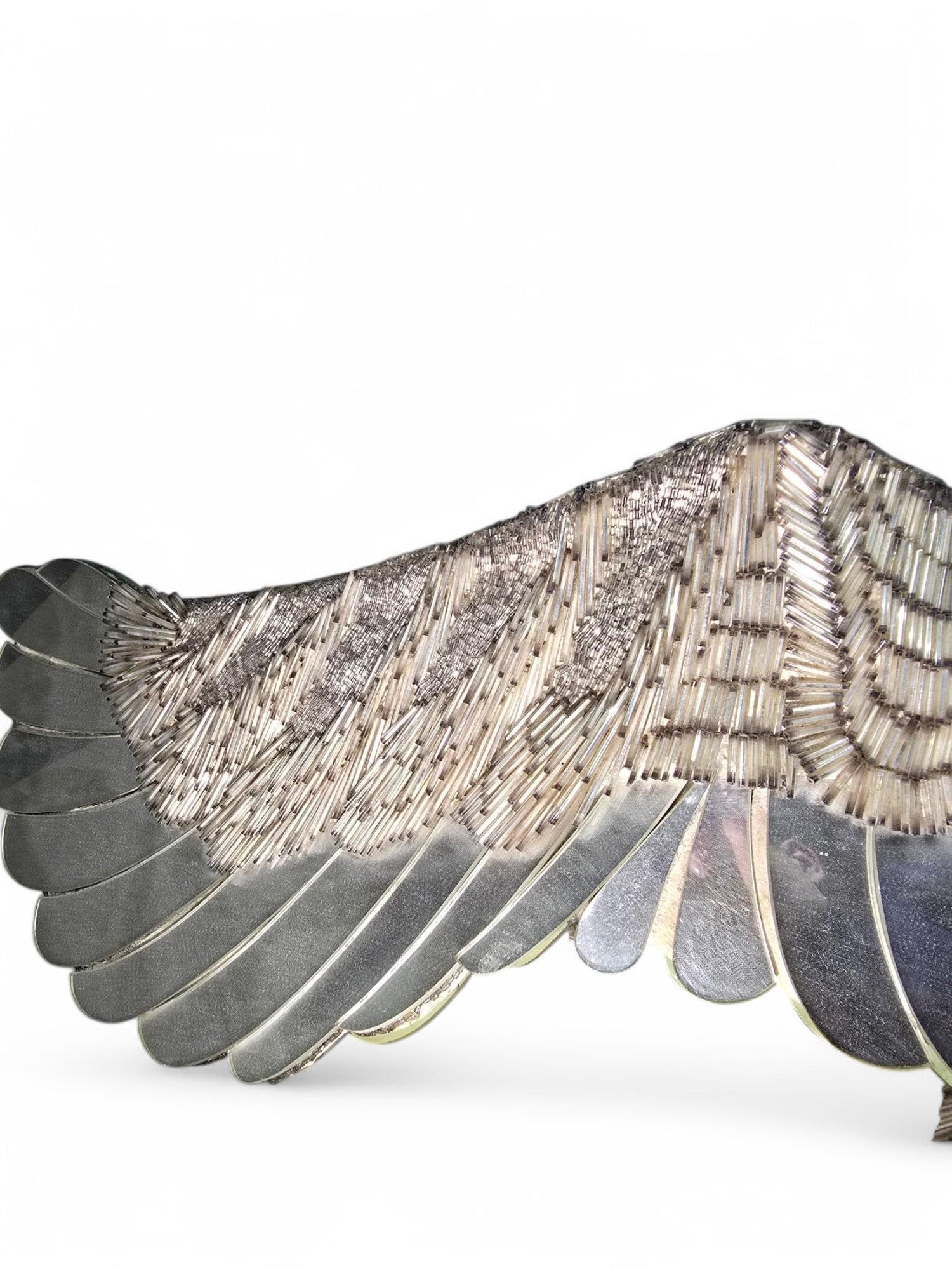 Magnifica e accattivante scultura di uccello decorativa, realizzata meticolosamente con perle di vetro e frammenti di specchio, che creano una superficie scintillante simile a un mosaico che cattura e riflette magnificamente la luce. Un vero e