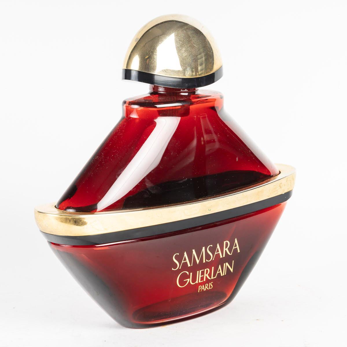 Grande bottiglia decorativa per il profumo Samsara, Guerlain, 1990.

Flacone decorativo d'epoca per il profumo Samsara di Guerlain in vetro e tappo d'oro, 1990.
H. H. 27 cm, L. 28 cm, P. 9 cm.
