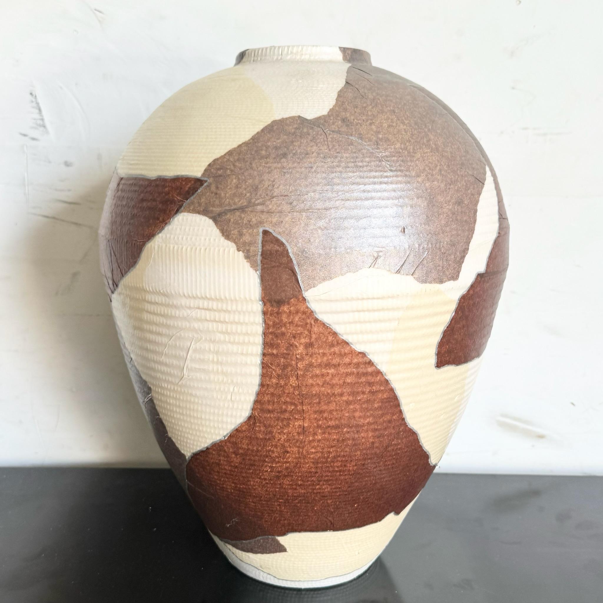 Ajoutez une touche unique à votre décor avec ce grand vase décoratif en carton brun et beige. Cette pièce distinctive associe un design moderne à des matériaux respectueux de l'environnement, ce qui en fait un complément idéal pour tout espace qui