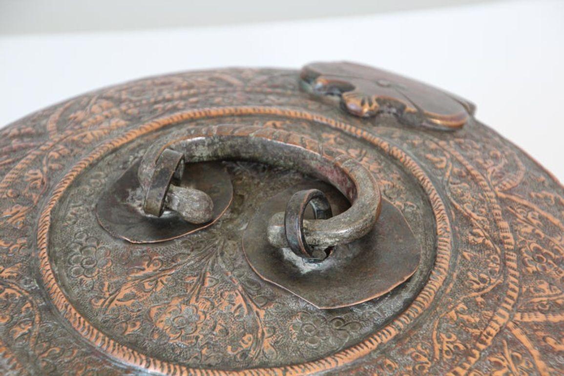 Magnifique boîte décorative indienne moghole en cuivre étamé avec couvercle, loquet et poignée.
Antique South Antiques Mughal Round Tinned Copper Box with Lid India 19th Century.
Boîte décorative ronde en cuivre étamé bronze d'Asie du Sud, ancienne,