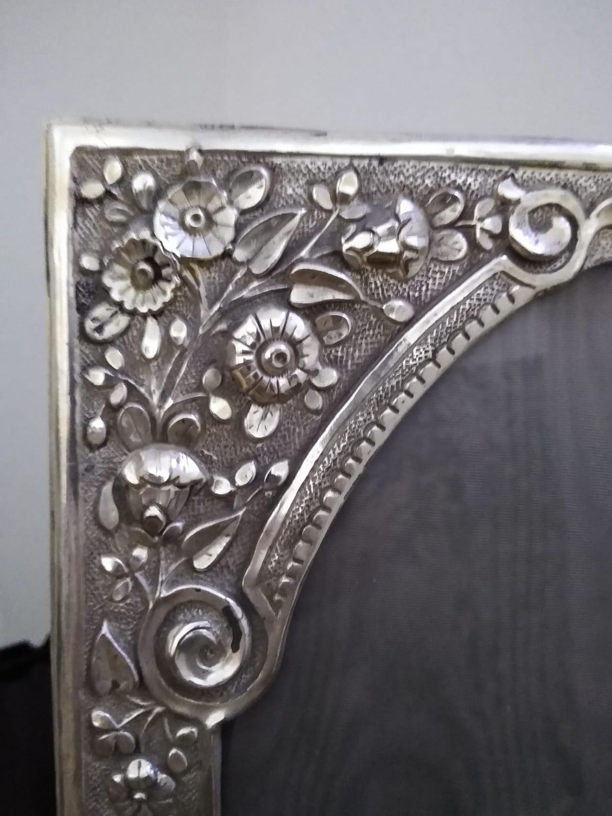 Un grand cadre photographique ancien, fait à la main, impressionnant et de grande qualité, avec une bordure en argent massif décorée de sections répétées de feuillage et de fleurs. Le dossier a été recouvert de velours bleu foncé.


