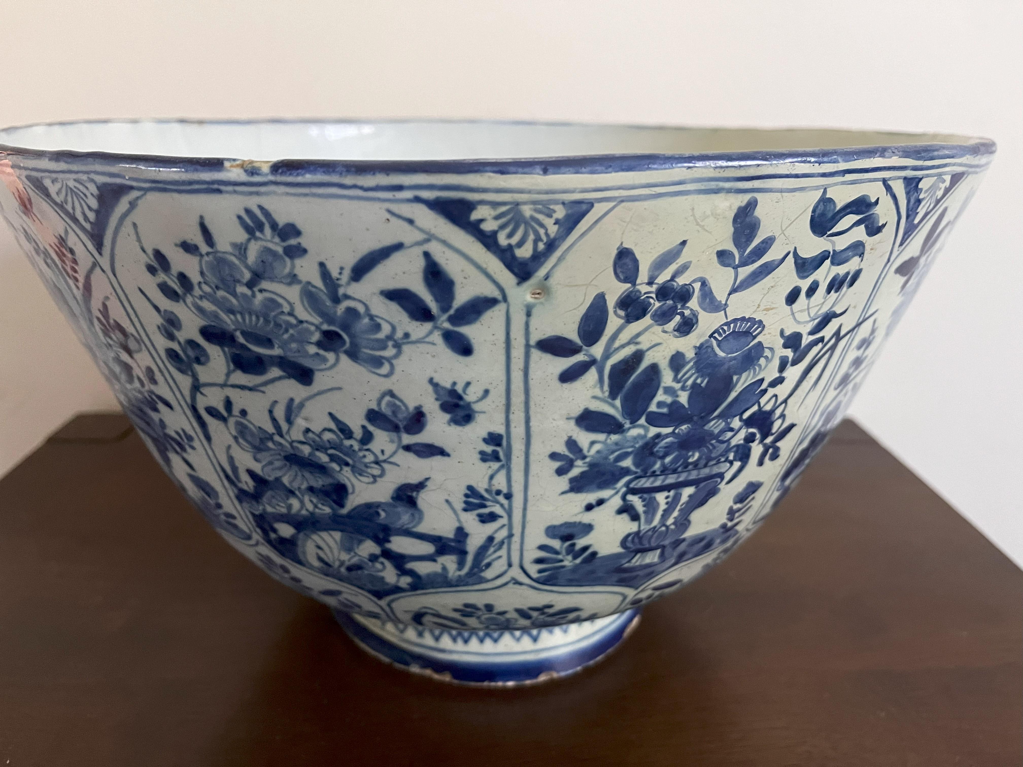 A large (14 inch / 35 cm diameter) antique Blue and White Delft punch bowl made in the 18th century, circa 1745. Probably English due to extensive flowery decoration and the reddish clay that is visible in the blemishes. 