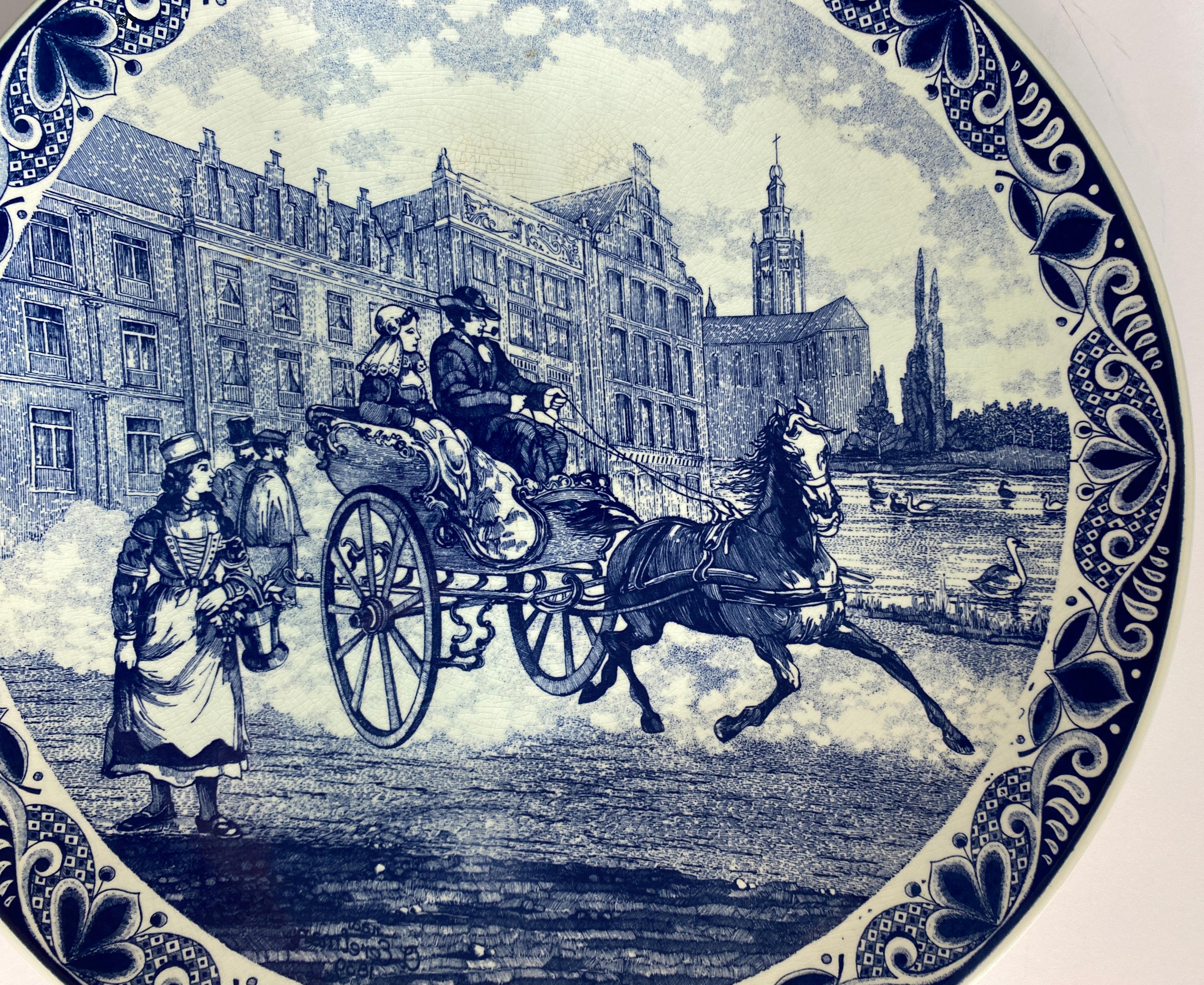 Großer Wandteller aus Delfter Porzellan, 
Blau-weiße Delfter Porzellanplakette mit einem Schloss im Hintergrund und einer Pferdekutsche und Menschen im Vordergrund. 

Die zentrale Szene ist lebendig und voller Energie und fängt die Essenz des Lebens