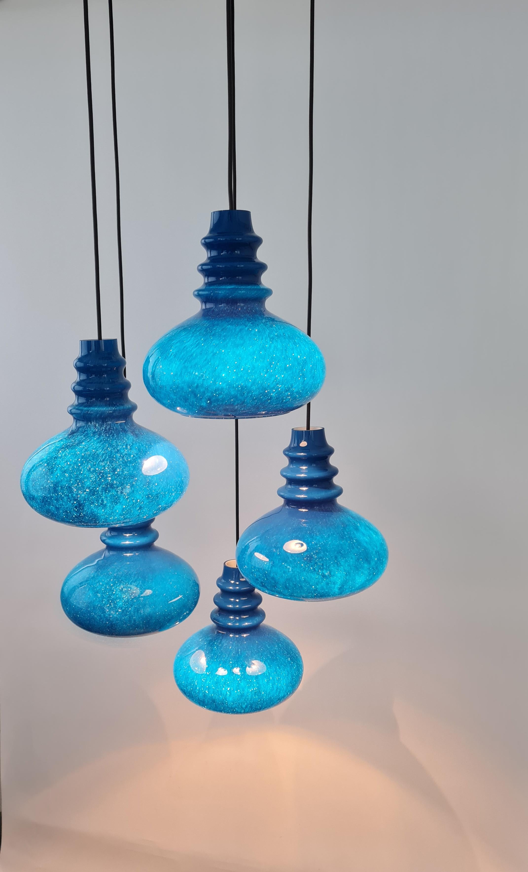 Un grand lustre spécial en cascade conçu par Wagenfeld pour Peill & Putzler Leuchten, fabriqué en Allemagne, vers les années 1970, avec 5 verres ronds bleus.
Une forme merveilleuse et un effet de lumière stupéfiant.

Douilles : 5 x ampoule