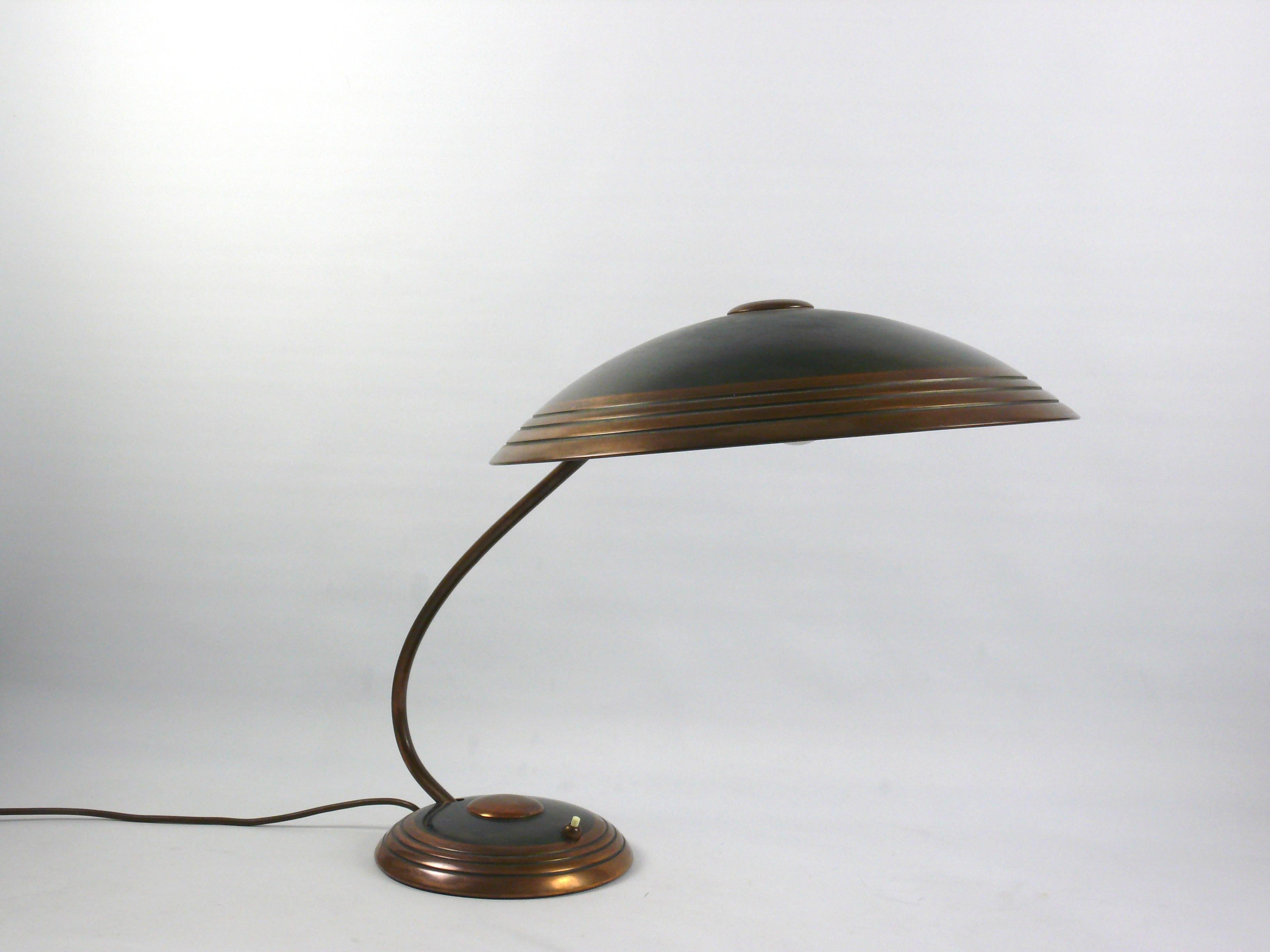 Large Helo table lamp with a very large shade and copper-plated brass areas - a timeless classic from the 1950s. Stylistically, the design of the lamp is based on the Bauhaus period. The lampshade can be adjusted in many ways using a ball joint. The