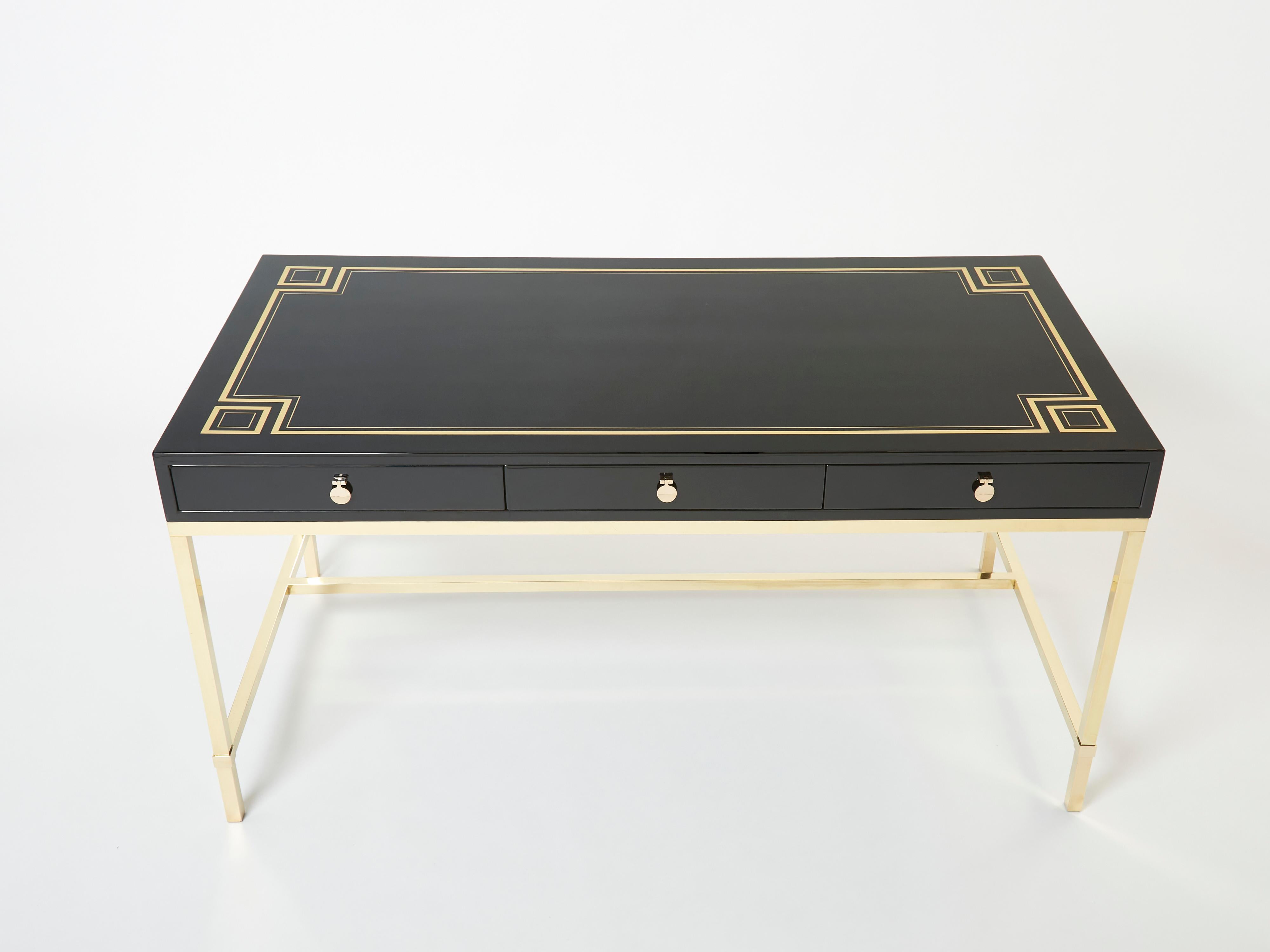A unique Maison Jansen black lacquered desk table designed by Guy Lefevre for Maison Jansen in the mid-1970s. It features a black lacquer top with neoclassical inspired brass inlays, and three drawers with beautiful brass handles, resting on a