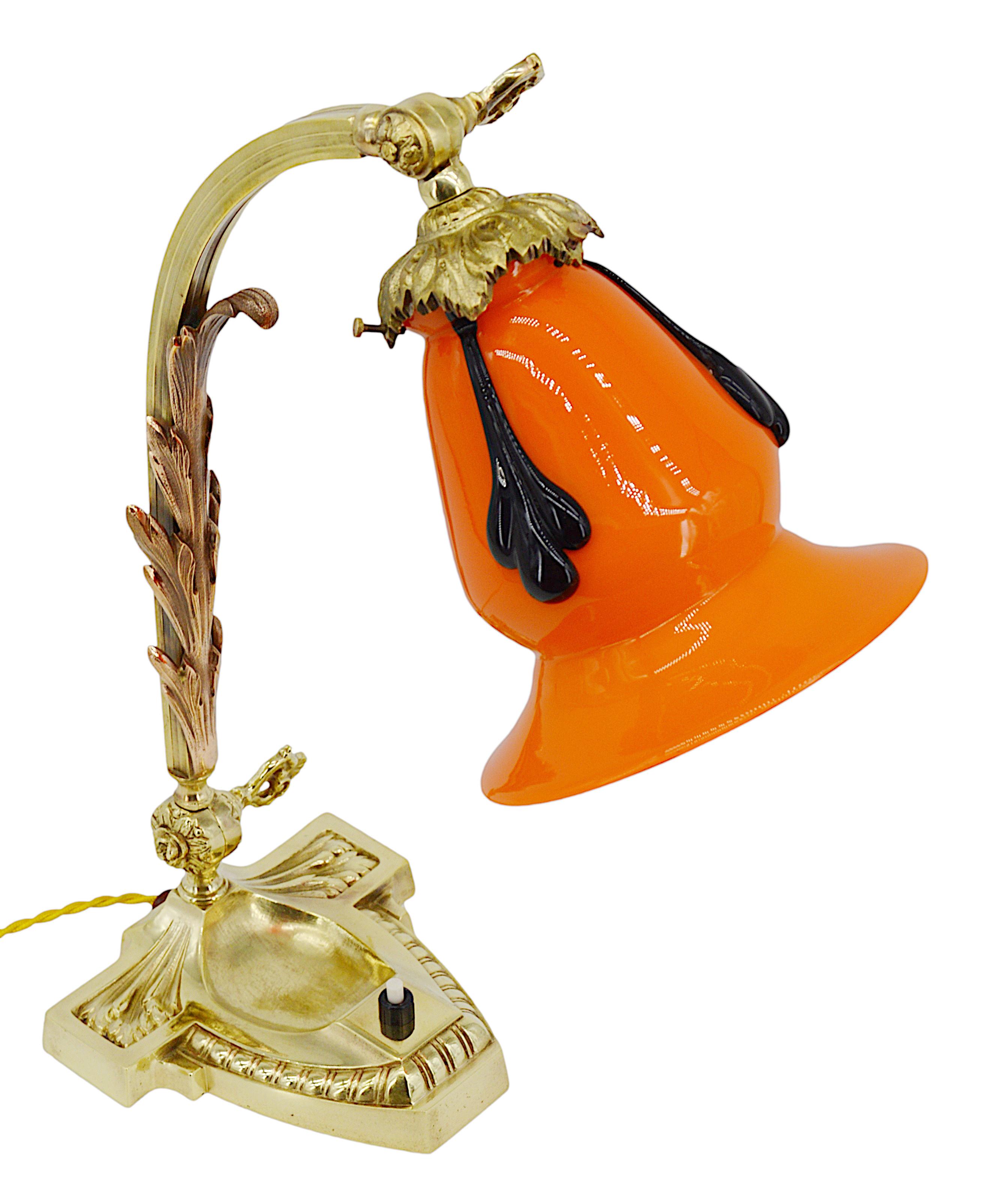 Swiveling desk / table lamp by Michael Powolny at Loetz, Bohemia, 1910s. Large double glass orange shade with three purple/black applications. Superb swiveling chiseled bronze base. Measures: Height: 15