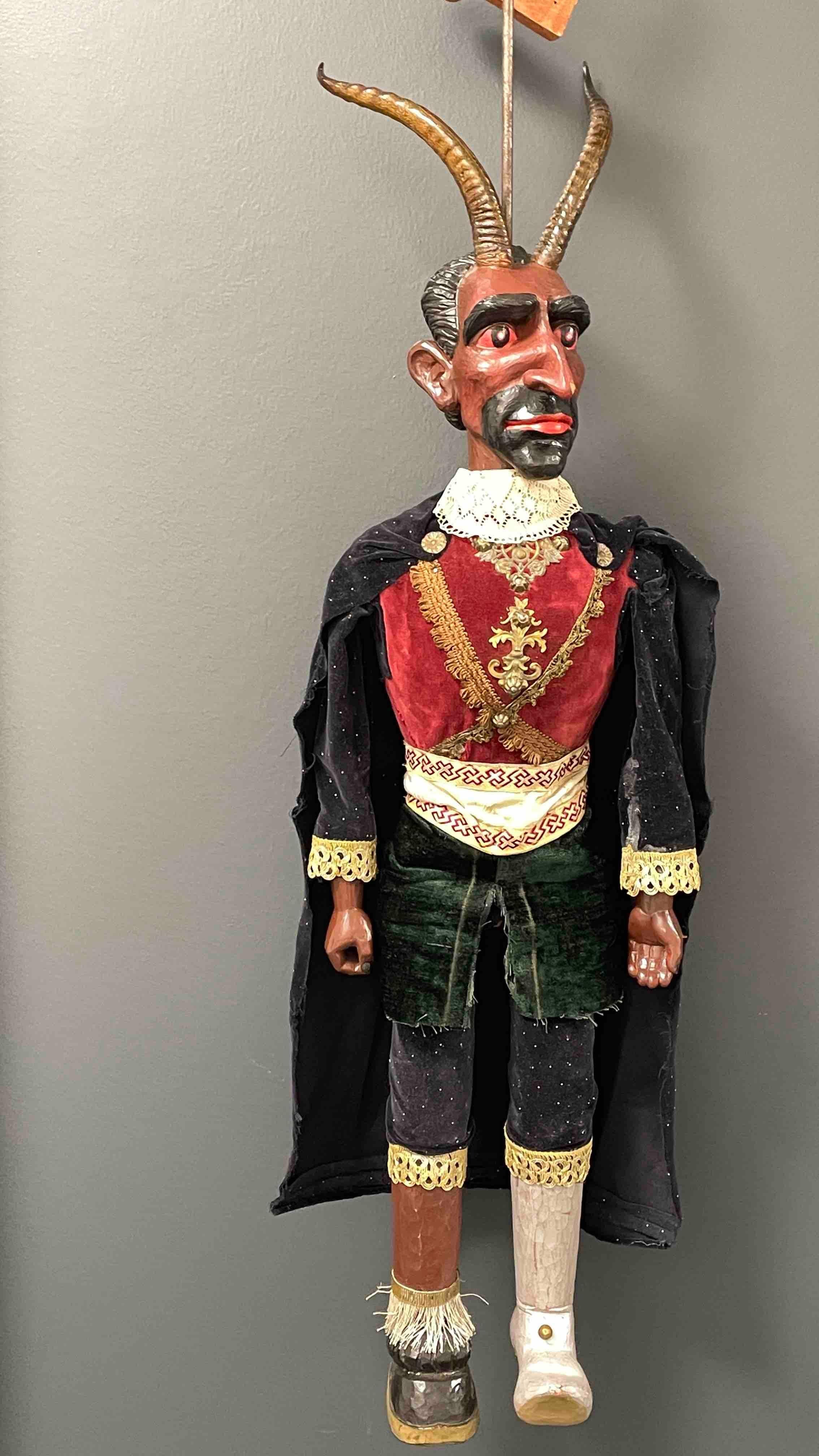 This is a wonderful depiction of Krampus or the devil puppet. The item is approximately 42 inches tall and has a skeleton, arms and legs made of wood. Height was measured from foot to the end of the horns. The head, hands and feet are carved from