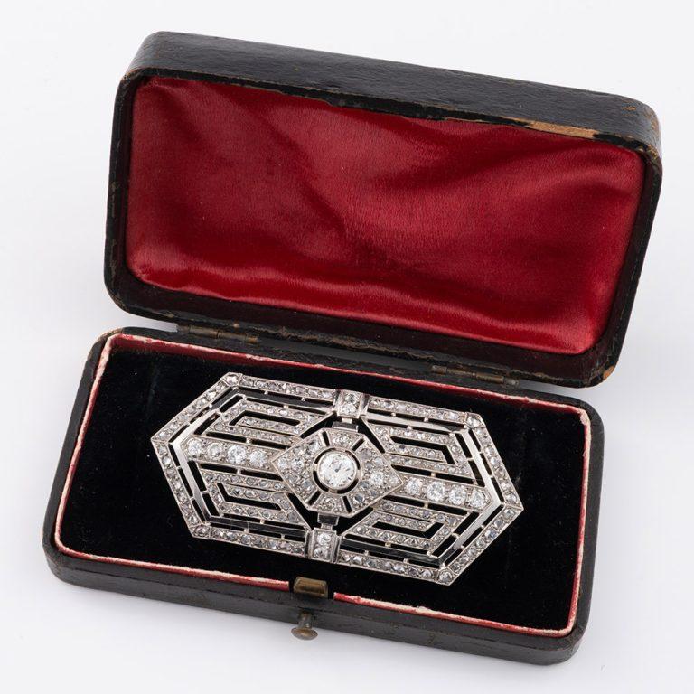 Heading : Large diamond brooch – French Art Deco jewellery 18ct gold
Date : c1935
Origin : France
Decoration : 18 carat white gold brooch with geometrically arranged diamonds within a hexagonal outline and greek key type arrangement within. Large