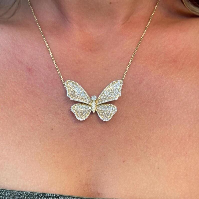 Grand collier à pendentif papillon comprenant de nombreux diamants de taille Asscher avec des brillants ronds en garniture et une face ronde brillante pesant 5,24 carats, en or jaune 18 carats.
Couleur G
Clarté VS2

Bague assortie disponible
Belle
