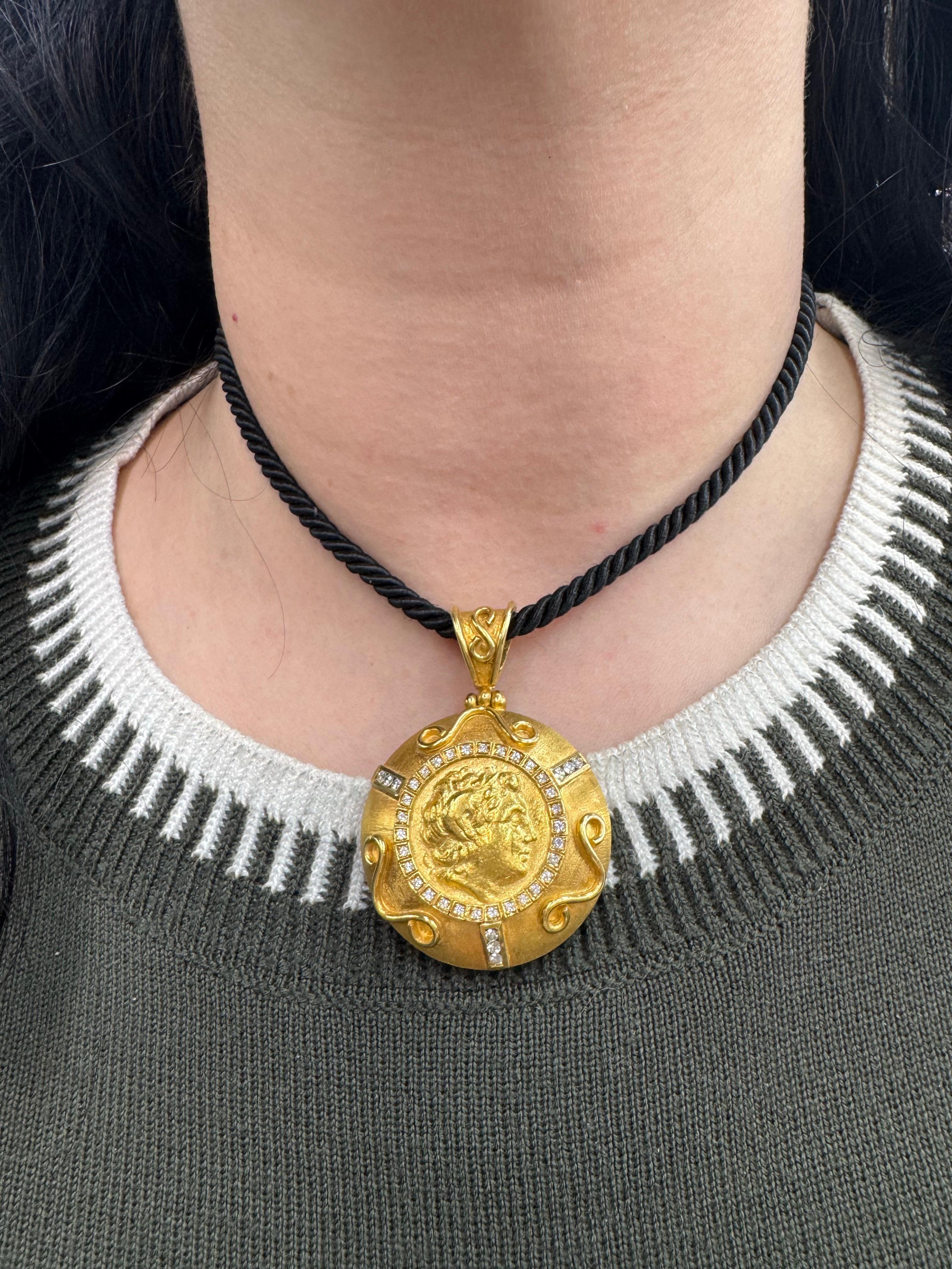 Un grand pendentif médaillon présentant un homme à motif gréco-romain entouré de brillants ronds pesant 0,68 carats, en or jaune 18 carats. 
14,5