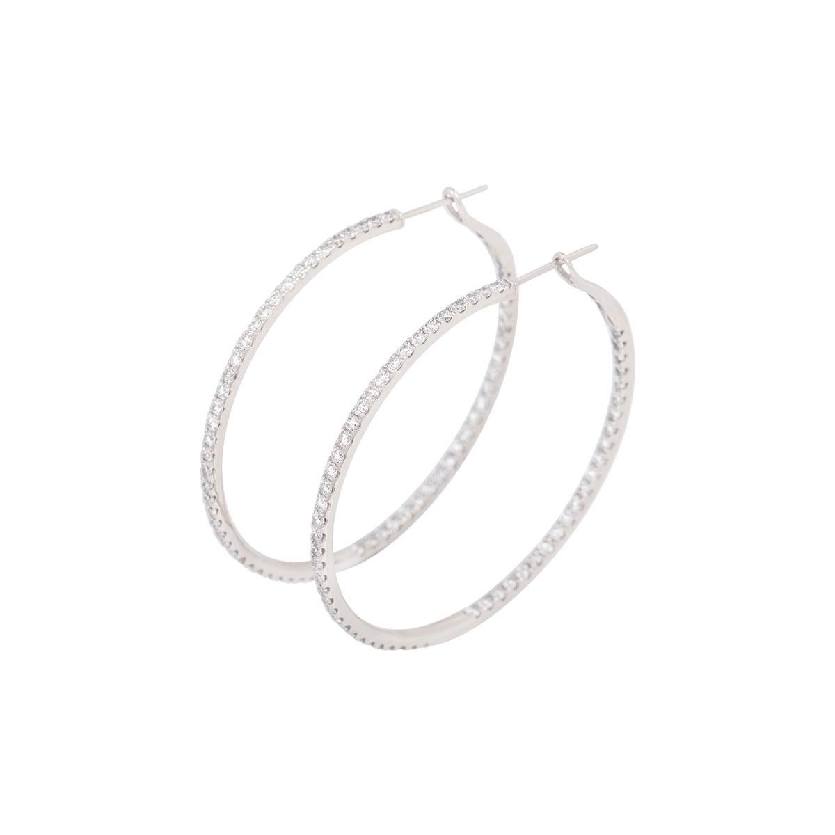 An 18k white gold pair of diamond hoop earrings. The earrings consist of 116 round brilliant cut diamonds set on the outer and inner line of the hoops with a total weight of 2.55ct, G/H colour and predominantly VS in clarity. The earrings feature