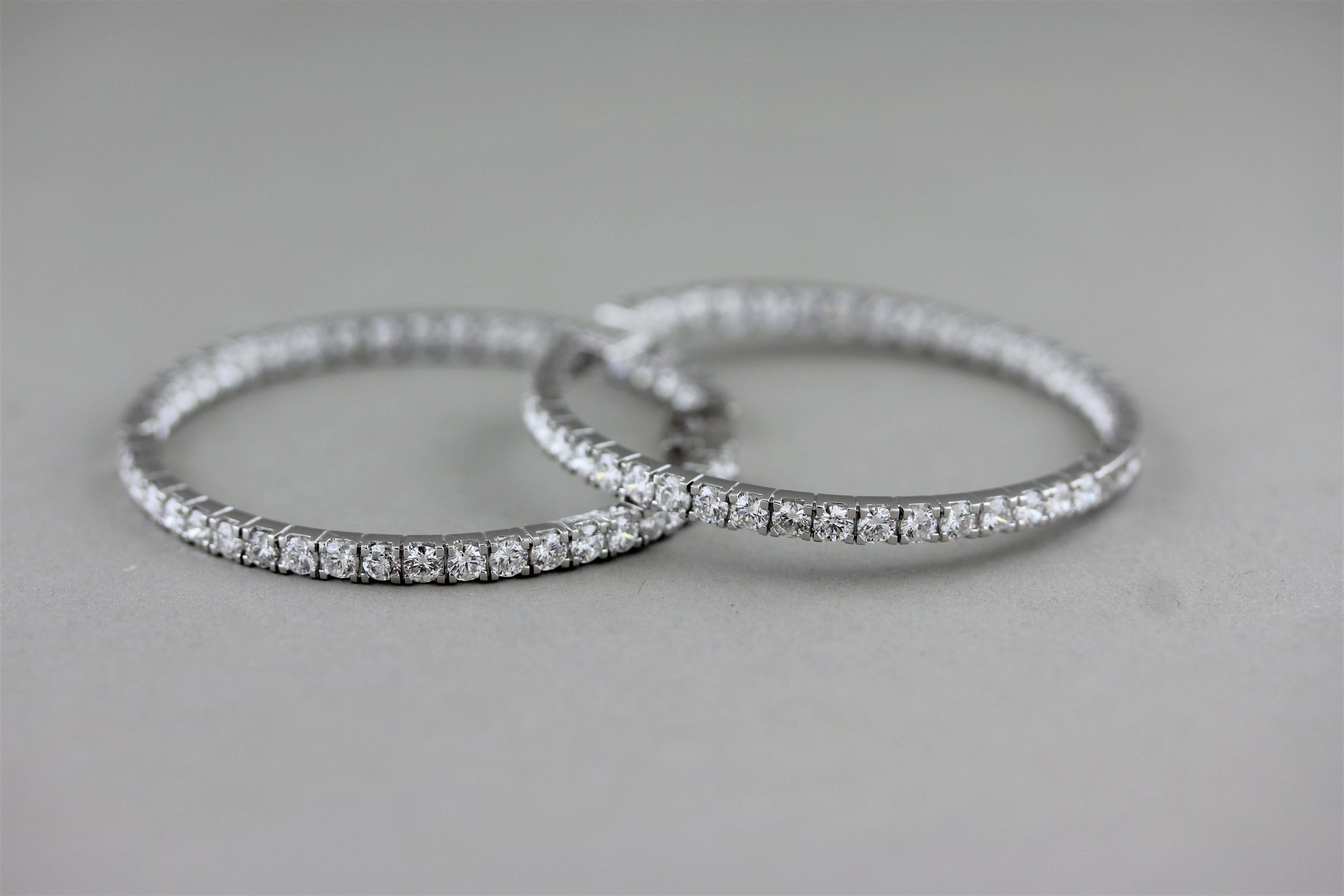 A large pair of classic inside-out hoop earrings. They are set with 5.70 carats of round brilliant cut diamonds on the inside and out giving the piece the illusion of diamonds set all around them. Made in 18k white gold these can be worn in the day