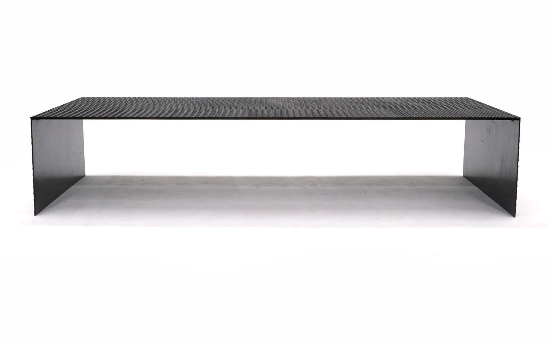 Eight feet long coffee table / bench custom made in diamond plate steel. Additional steel supports keep the piece structurally sound and flat. One of a kind and in very good to excellent condition. Measure: 8ft.