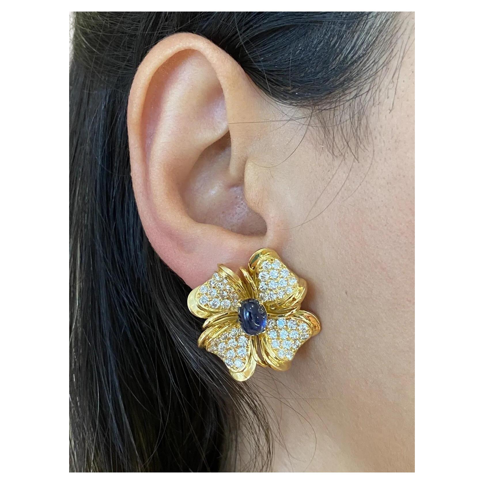 Boucles d'oreilles fleurs en or jaune 18 carats, diamants et saphirs

Les boucles d'oreilles Fleur de saphir et de diamant présentent des diamants ronds et brillants sertis en pavé dans un motif de fleur avec un saphir bleu cabochon de forme ovale