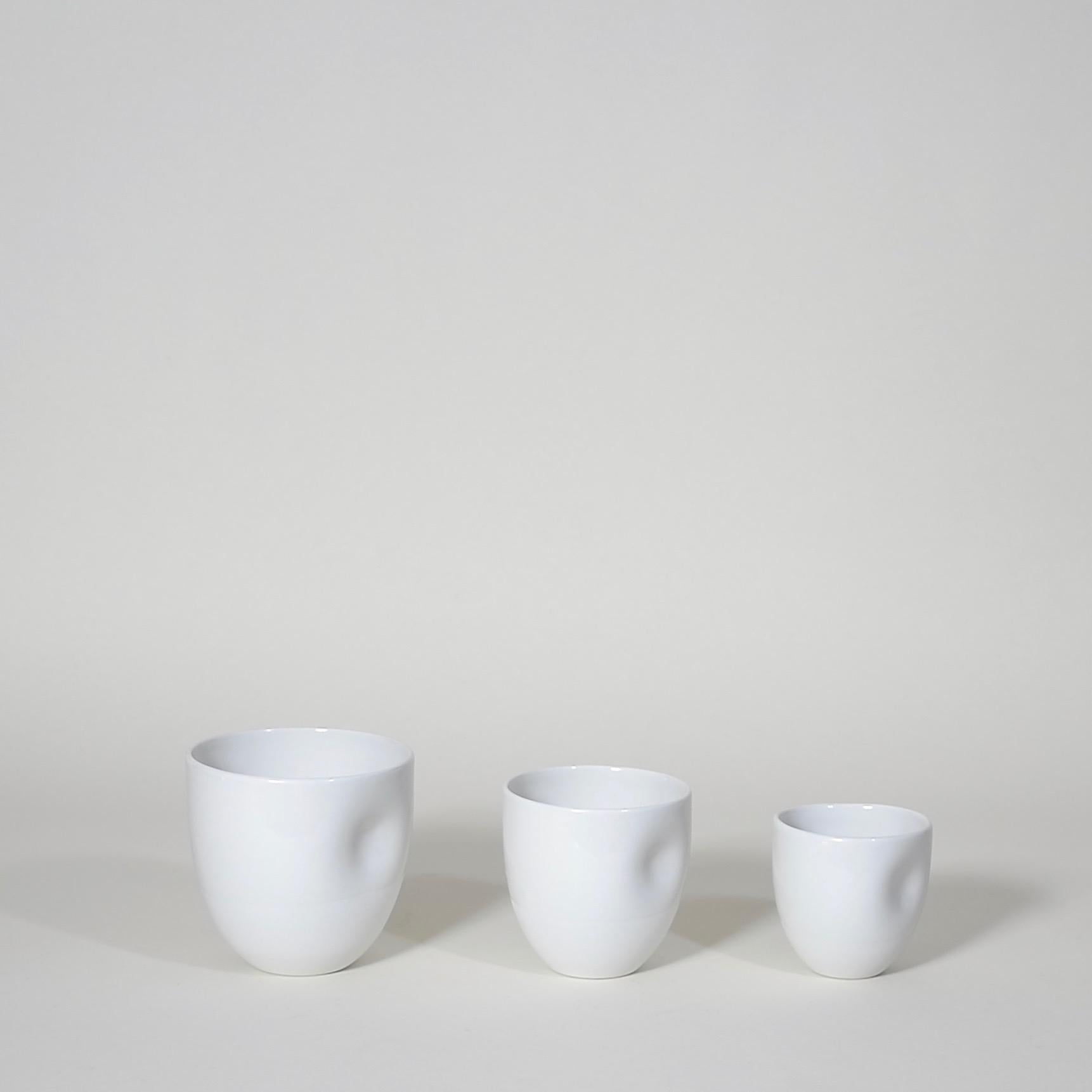 Middle Kingdom dimpled porcelain cups are designed by Carola Zee of Rotterdam, Holland. Each cup is molded and then dimpled by the hand of the potter to create a unique and comfortable hold. There are three sizes available, three colors, and