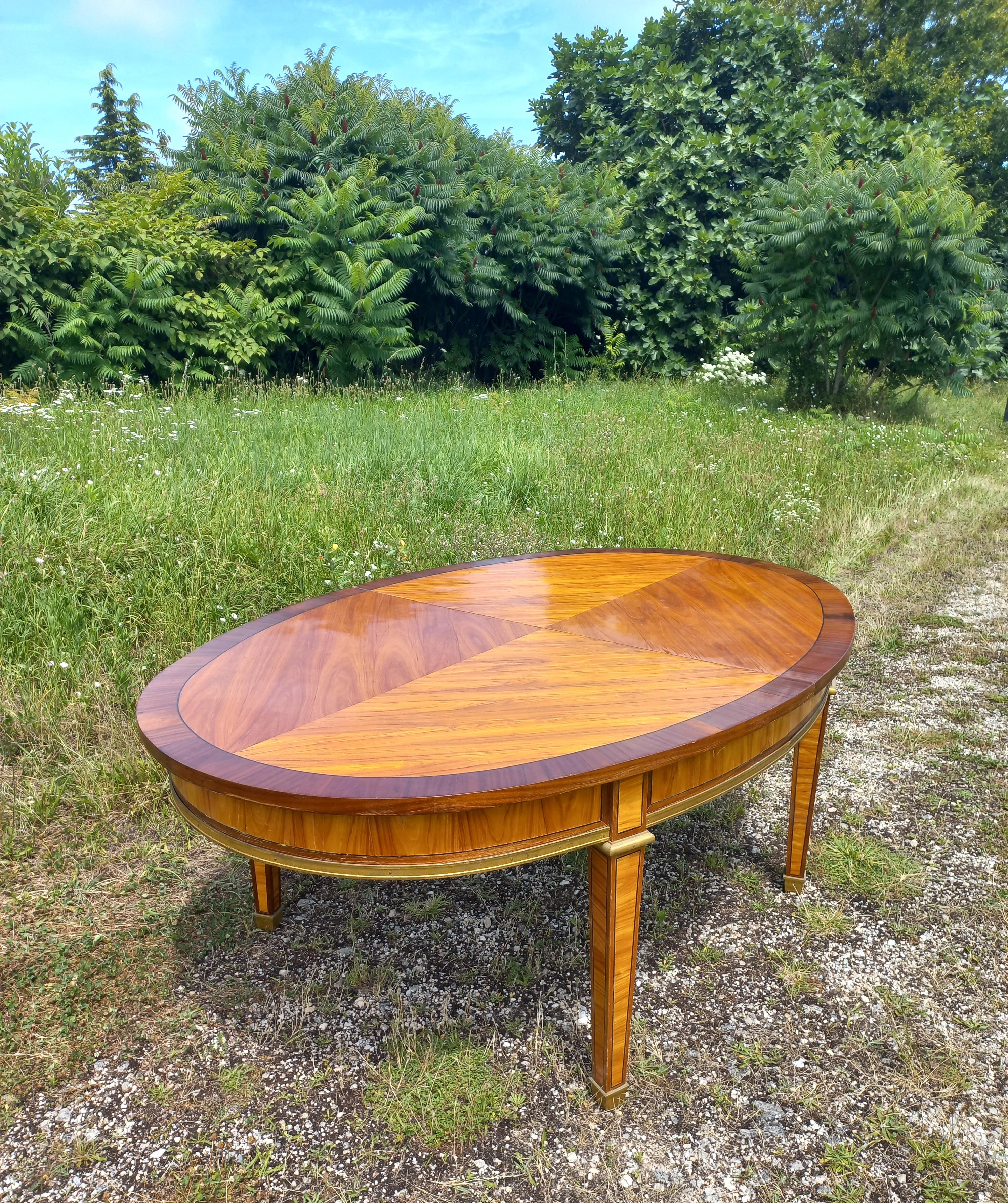 Large reception or dining room table in rosewood marquetry, satin wood, ebony fillet and gilded bronze. It opens with 5 extensions of 94.490 inches, total open dimensions 173.230 inches, closed dimensions 75.590 inches x 51.180 inches, height 29.528