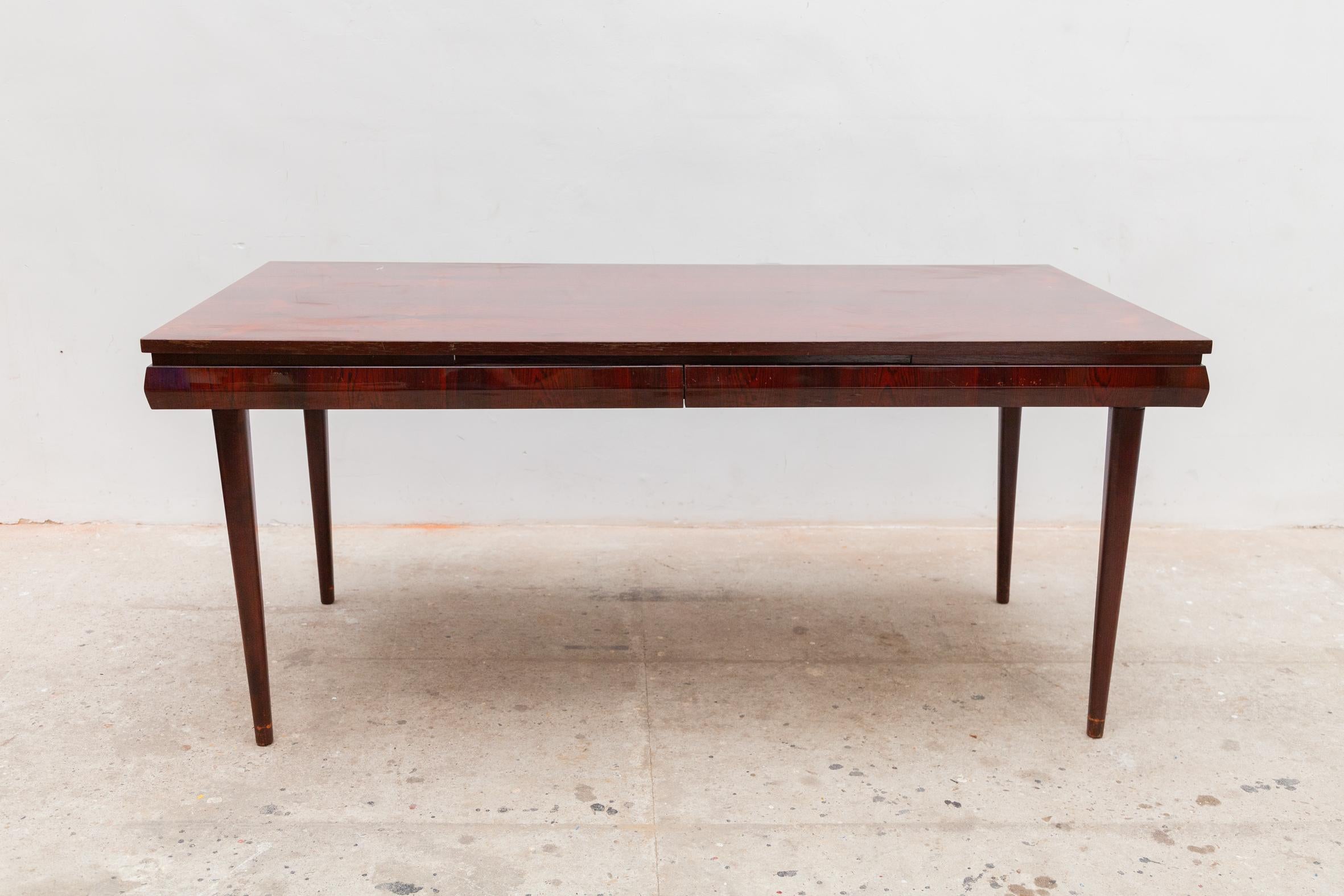 This is a superb 1950s Italian dining table attributed to Paolo Buffa. A beautiful dining room table in mahogany colored walnut that is also extendable on both sides to a length of 280 cm.
The curved edge around the table in which the inner leaves