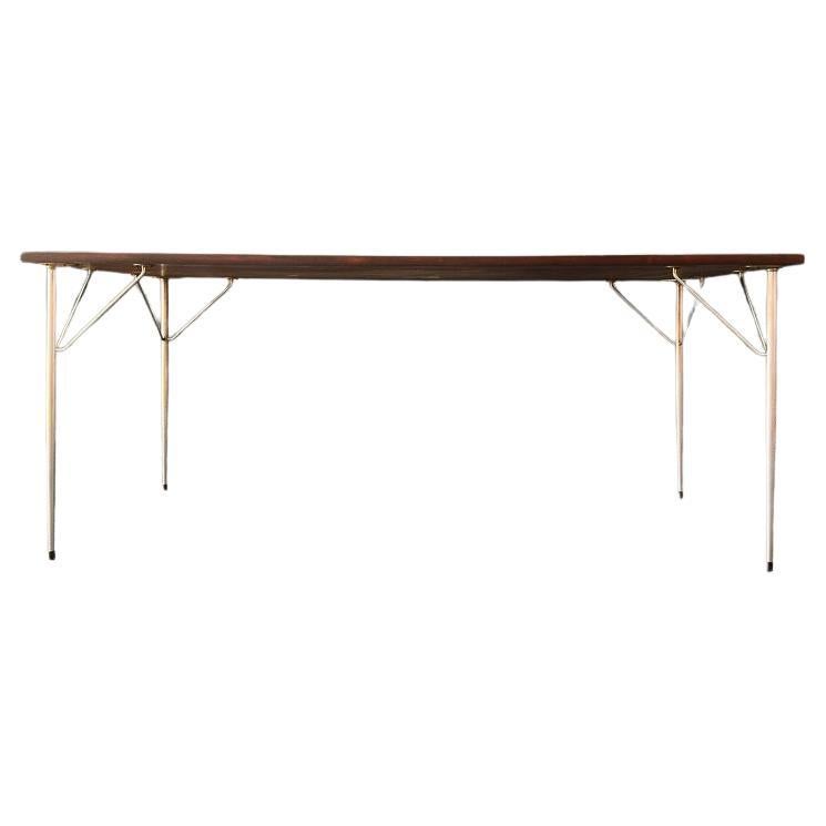 Cette grande table est dotée d'un superbe plateau en bois dur riche, aux couleurs magnifiques et au grain prononcé, dont le toucher luxueux complète la simplicité du design de cette pièce. Le plateau en bois repose sur des pieds en acier élégants
